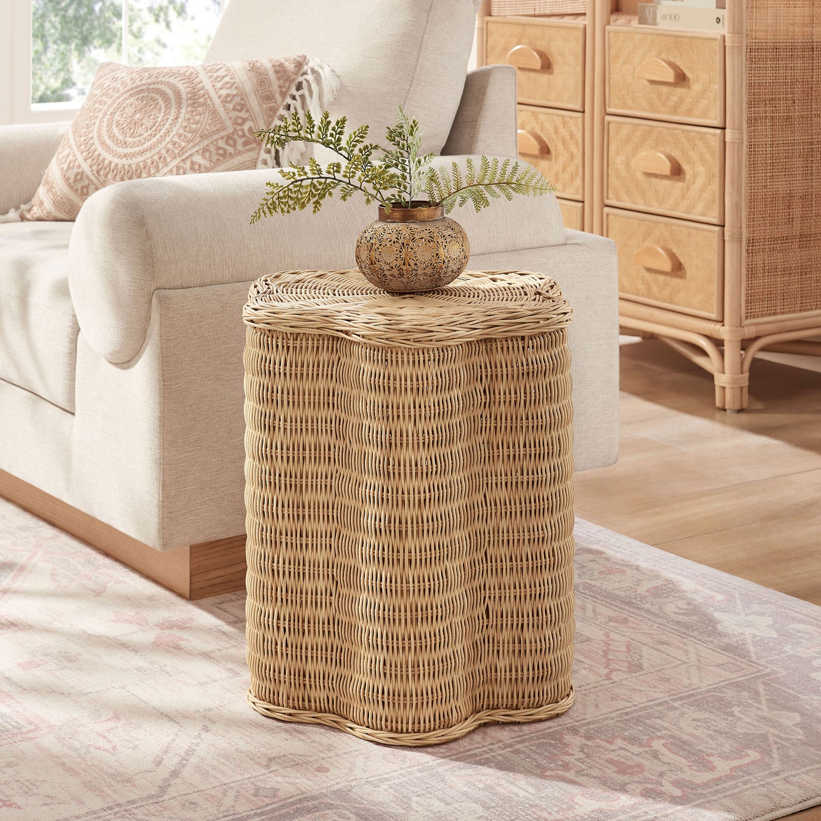 Natural rattan scalloped side table adding airy texture next to a modern upholstered sofa || EEI-7366-NAT || front_angle_room