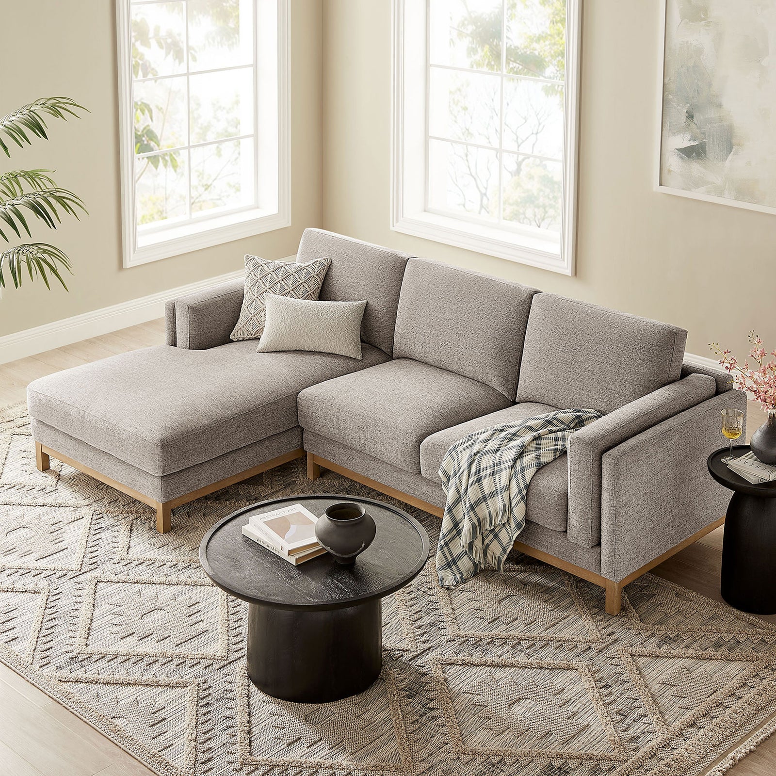 Left-facing pewter sectional arranged on a patterned area rug with layered pillows and cozy throw blanket. || EEI-7374-PEW || front_angle_room