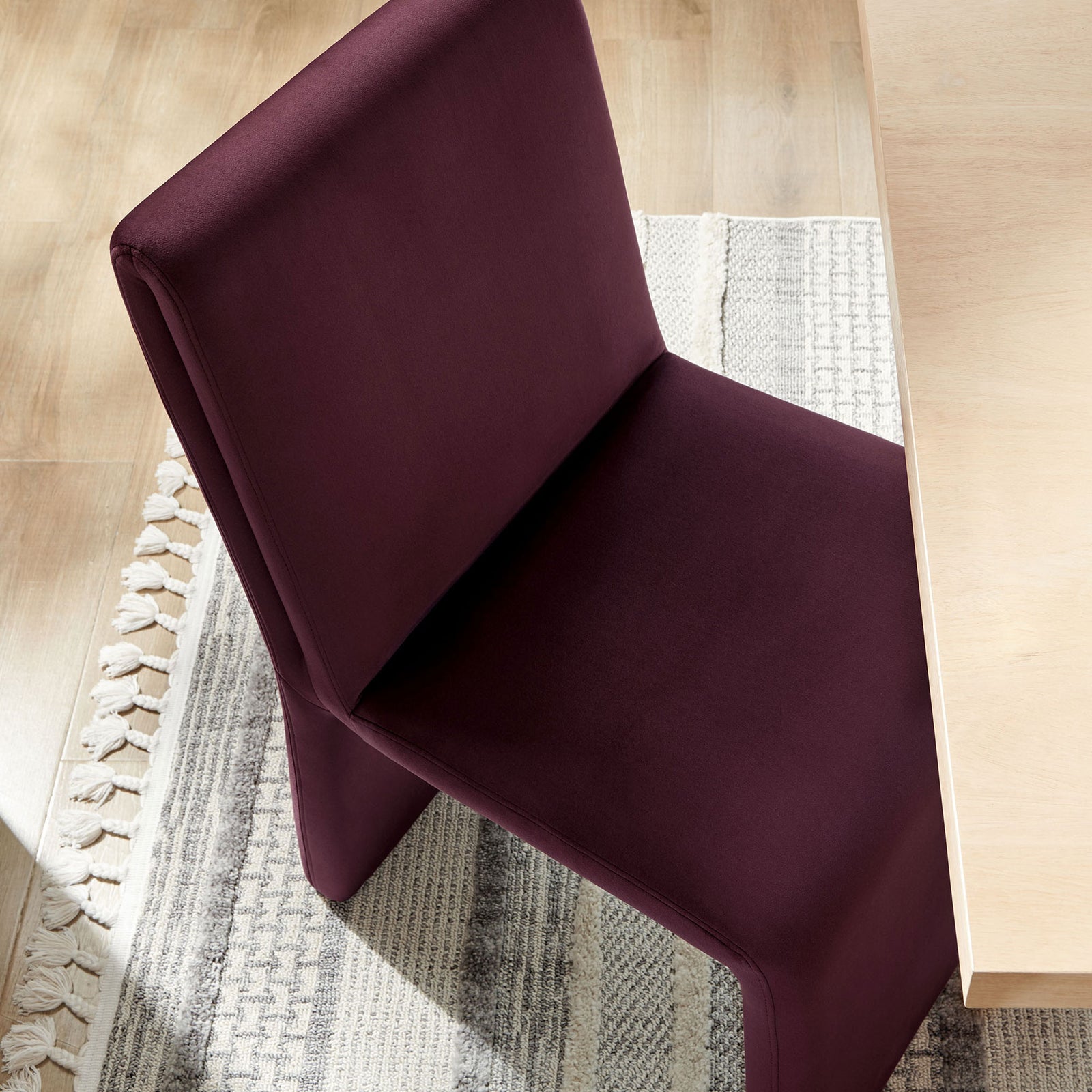 Mulberry velvet dining chair tucked to a light wood table over a textured neutral rug || EEI-7384-MUL || detail_room