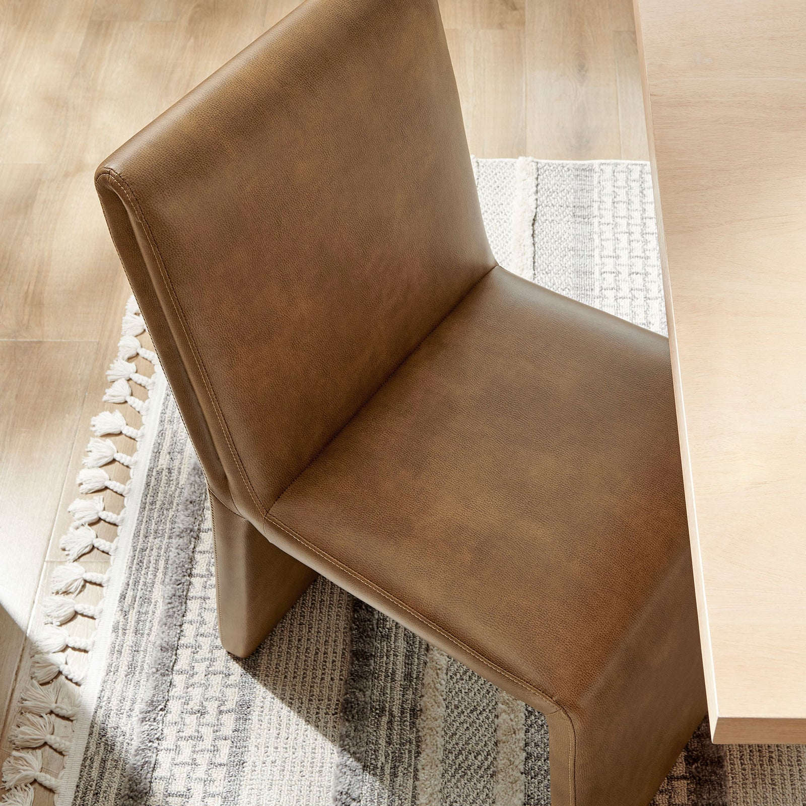Canyon vegan leather dining chair paired with a light wood table and textured rug for warm modern style || EEI-7385-CYN || top_angle_room