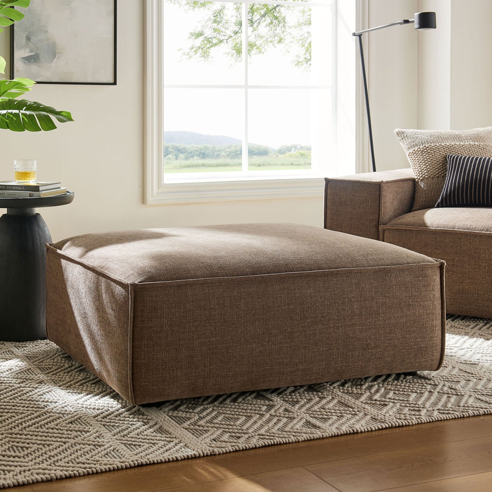 Modern mocha ottoman anchors a bright living room, offering generous cushioned comfort in performance fabric || EEI-7401-MOC || front_angle_room
