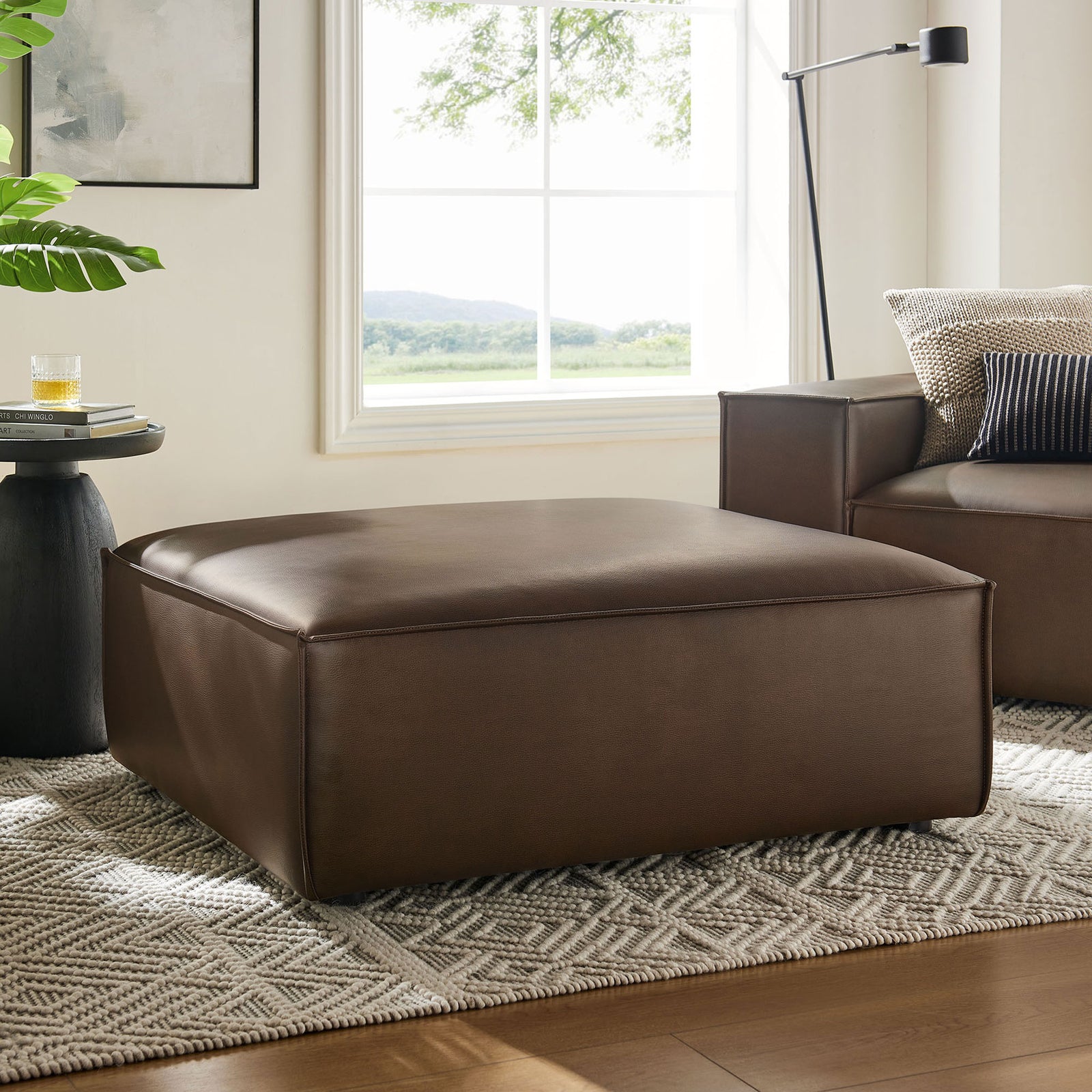 Vegan leather ottoman anchors a modern living room, pairing seamlessly with the matching modular sofa. || EEI-7402-ESP || front_angle_room