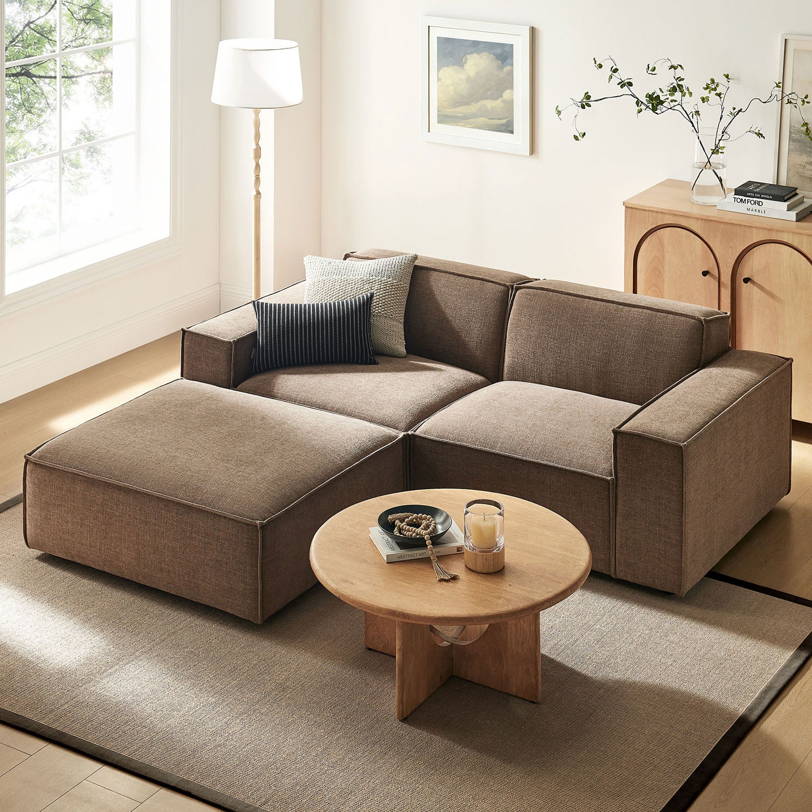 Spacious mocha loveseat with ottoman creates a cozy lounge area, paired with a modern coffee table and decor. || EEI-7405-MOC || front_angle_room