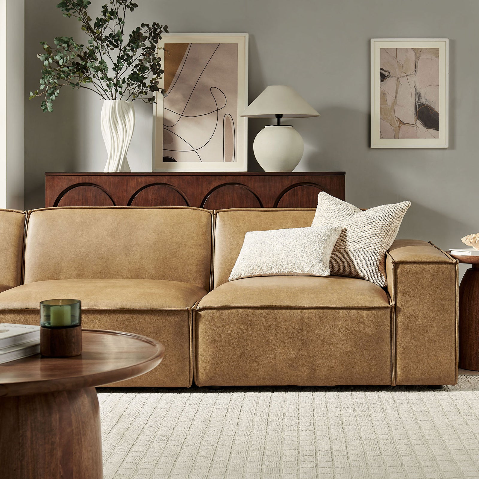 Cozy corner of the toast modular sofa accented with textured throw pillows and warm wood decor. || EEI-7408-TST || detail_room