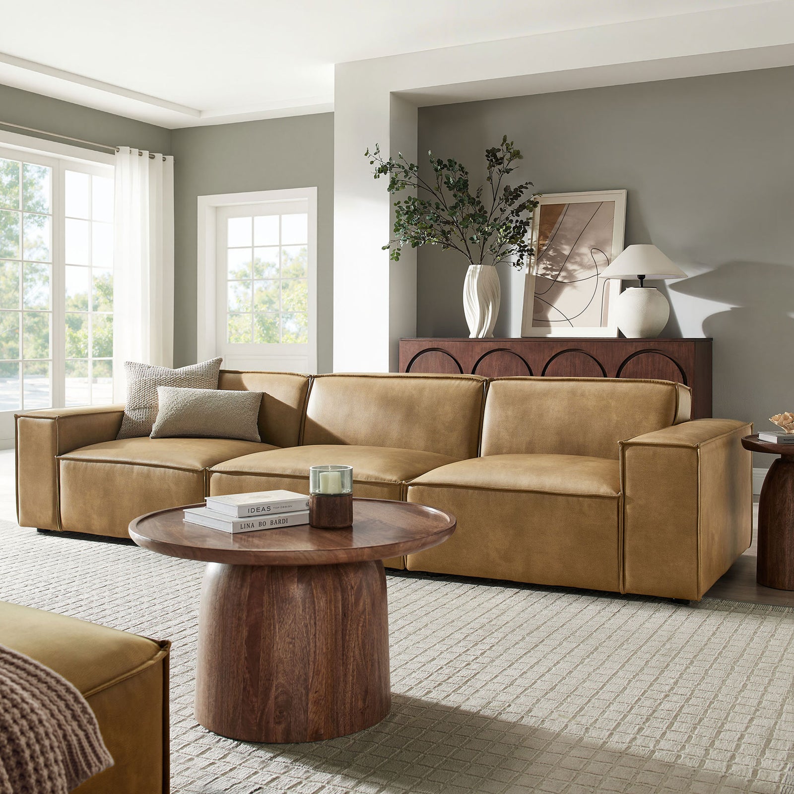 Toast vegan leather modular sofa styled in a bright living room with coordinating wood table and console. || EEI-7408-TST || front_angle_room