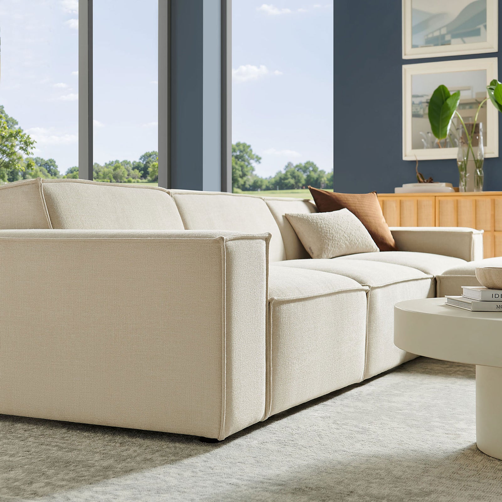 Ecru modular sofa with wide arms and plush cushions styled in a bright contemporary living room || EEI-7409-ECR || detail_room
