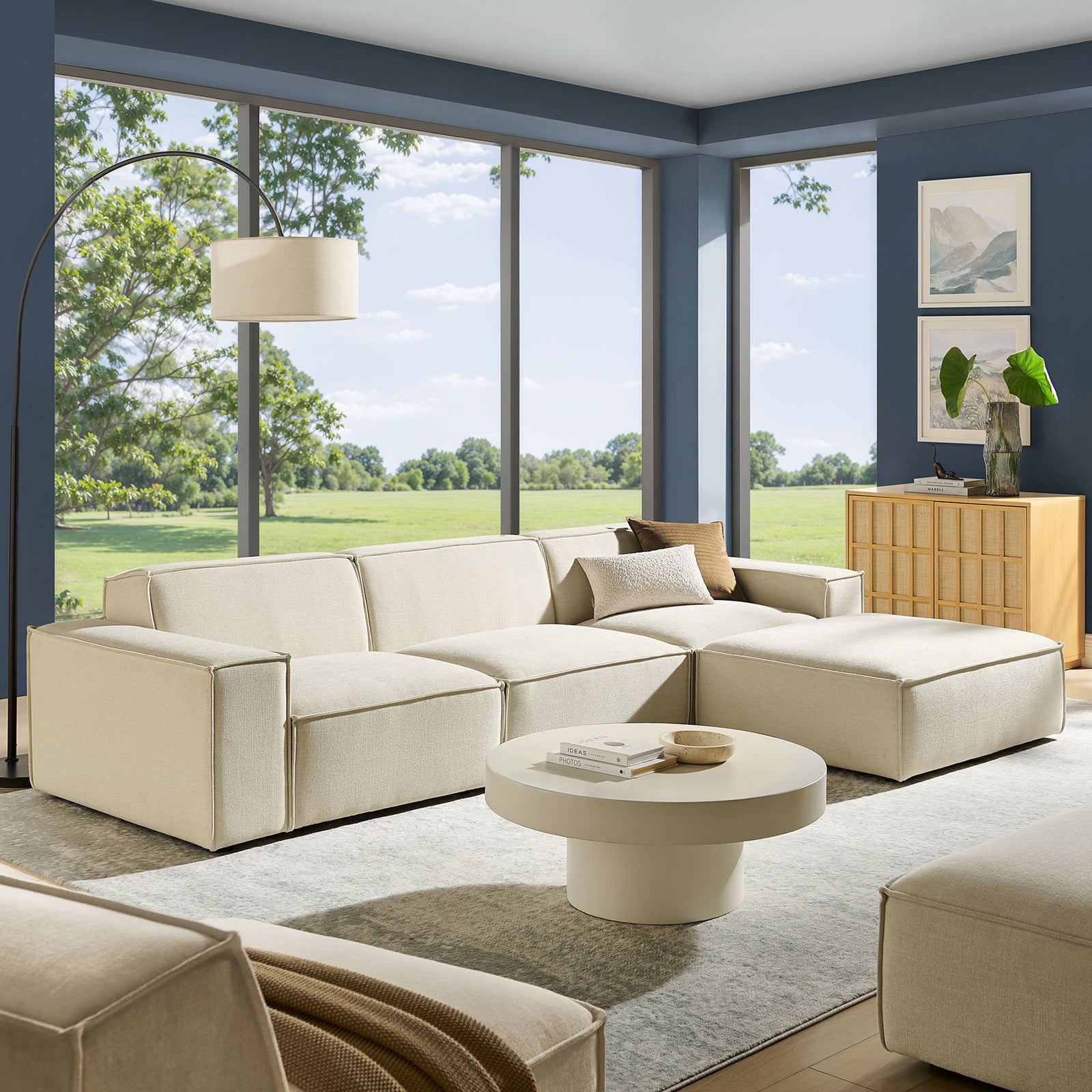 Spacious living room featuring the ecru modular sofa set with ottoman, rug, and modern decor || EEI-7409-ECR || front_angle_room