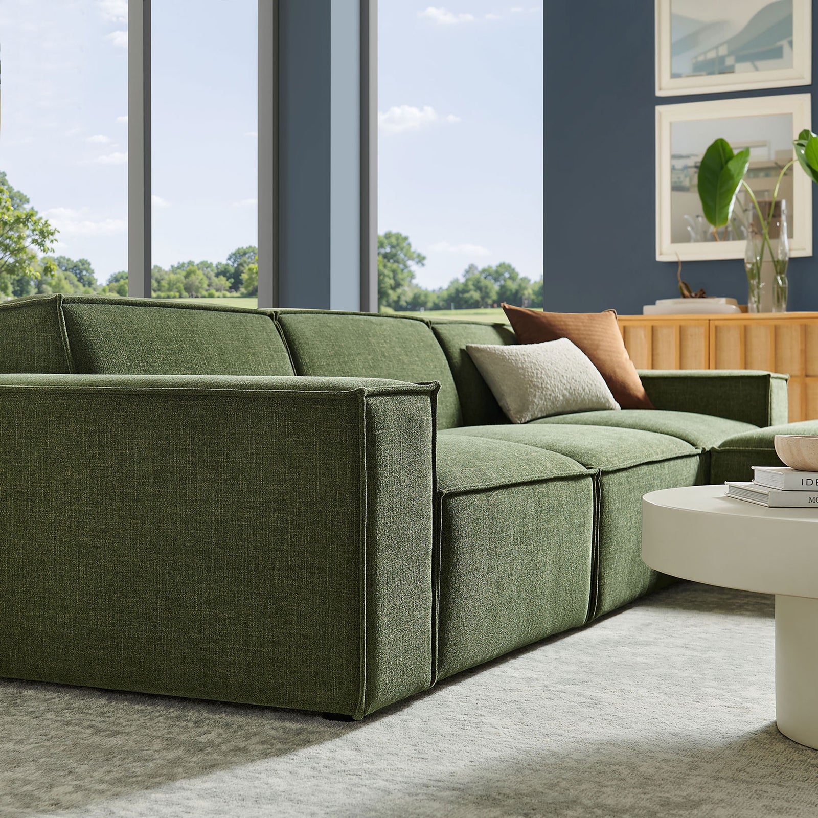 Side view of the green modular sofa showing generous seat depth and structured track arms || EEI-7409-FOL || front_angle_partial_room