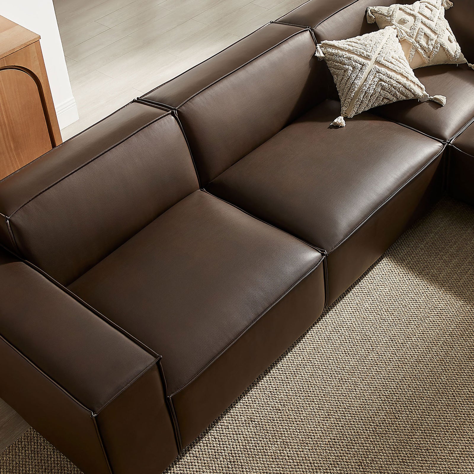Plush espresso vegan leather seats with French piping details layered over a warm, textured neutral rug || EEI-7412-ESP || detail_room