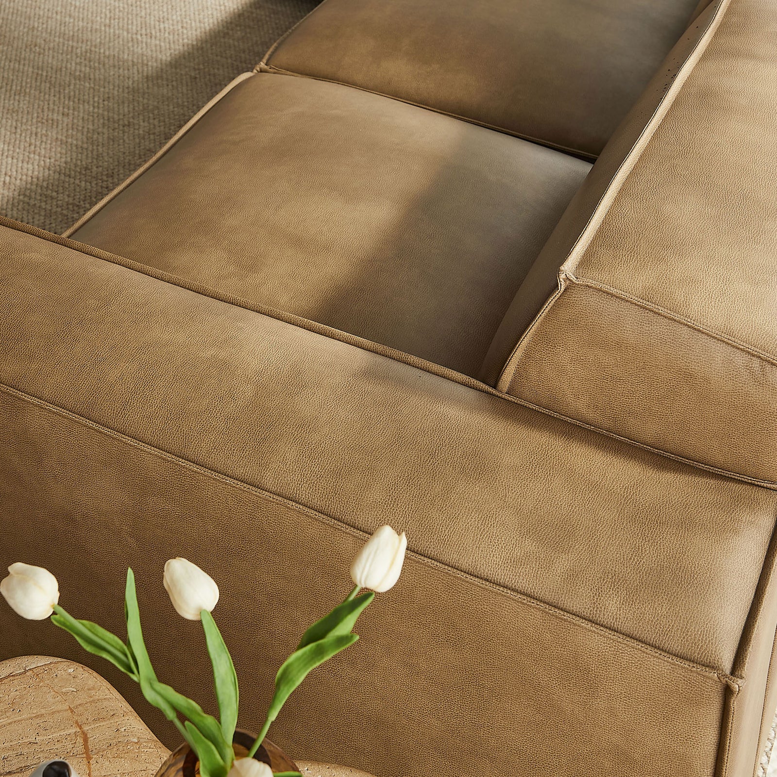 Toast vegan leather seat cushions showcasing subtle texture next to a decorative side table || EEI-7412-TST || detail_room