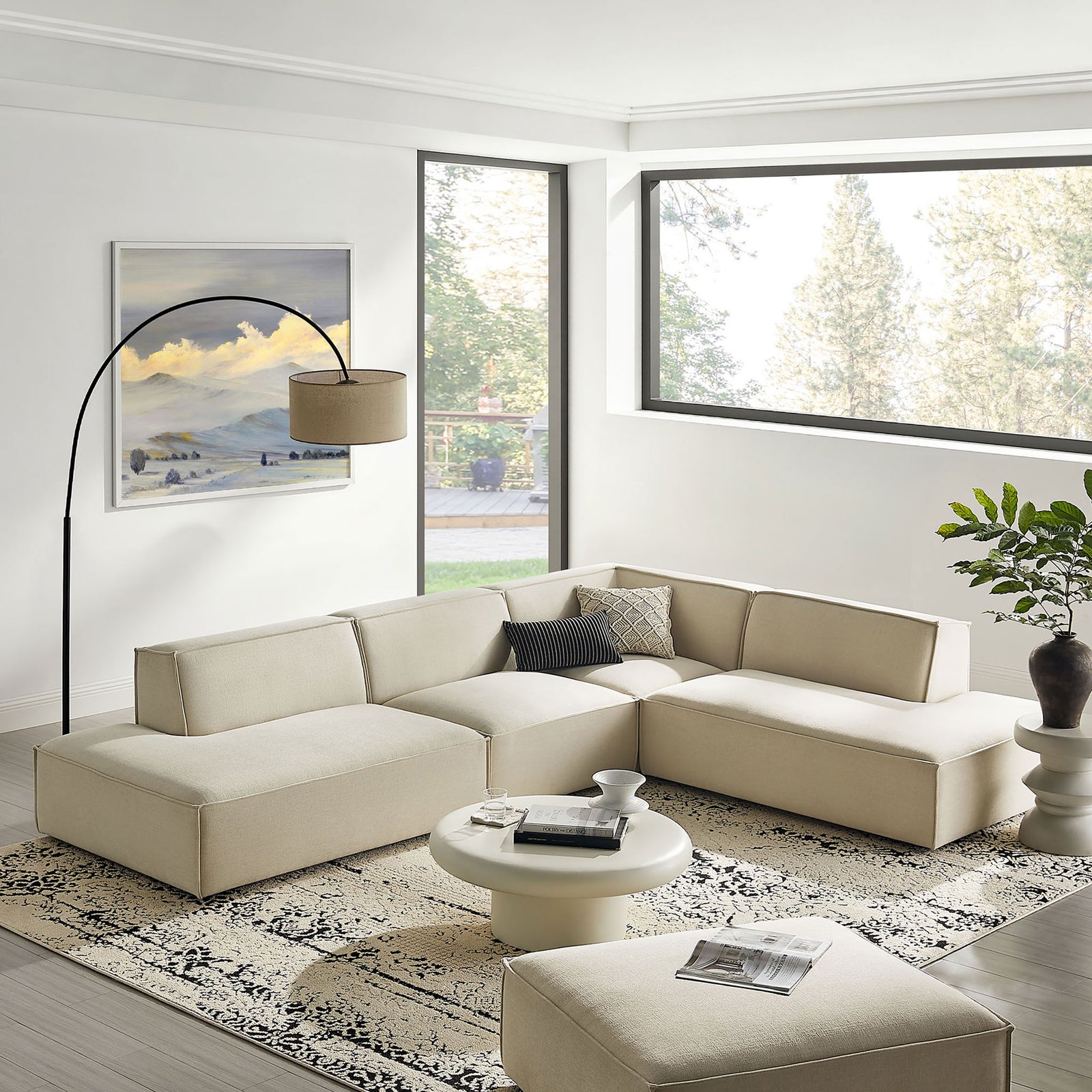 Ecru modular sectional anchors a bright living room with modern rug, round coffee table, and floor lamp. || EEI-7413-ECR || front_angle_room
