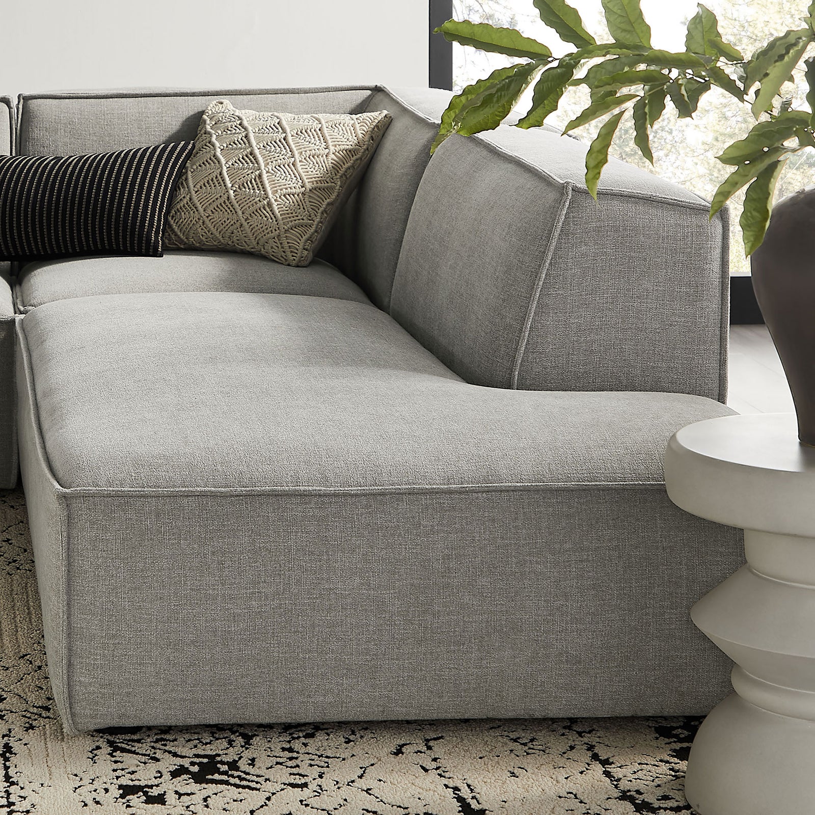 Corner of pewter modular sectional styled with textured accent pillows for cozy lounge seating || EEI-7413-PEW || detail_room