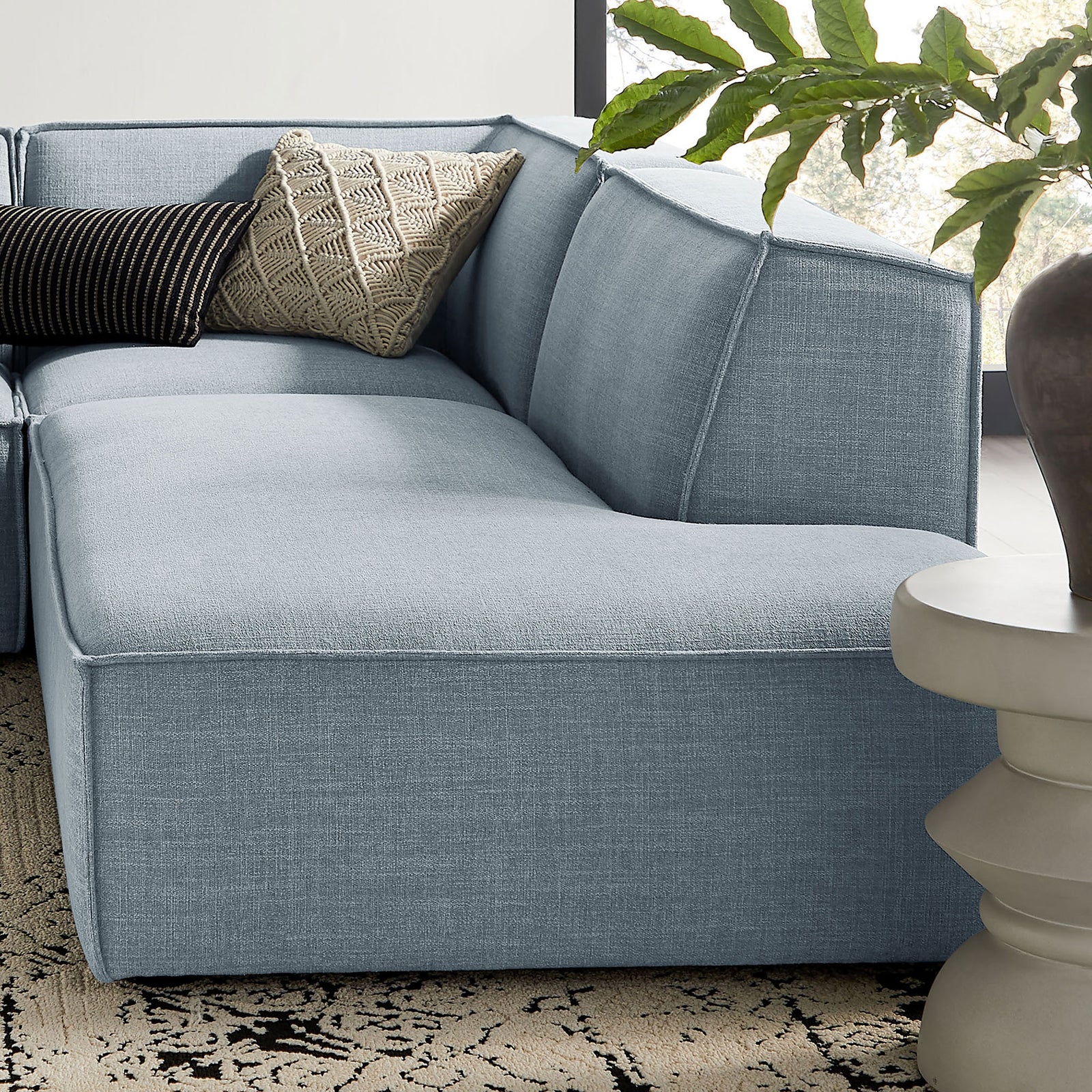 Detail of sky blue sectional corner with layered accent pillows and crisp French-piped cushions. || EEI-7413-SKY || detail_room