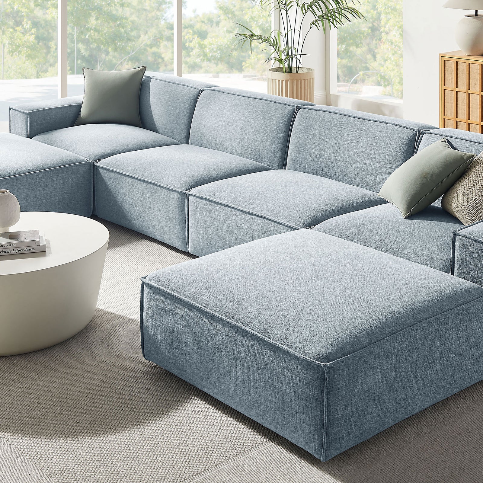 Sky blue modular sectional anchored in a bright living room with round coffee table || EEI-7417-SKY || front_angle_room