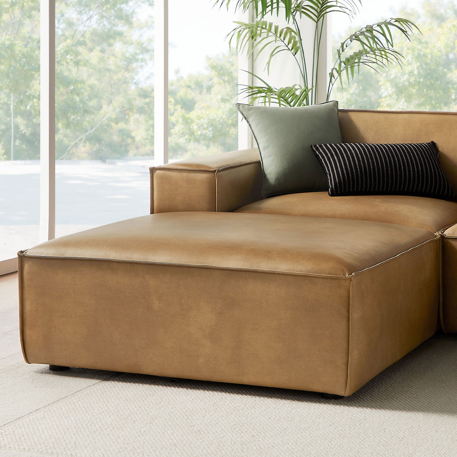 Toast vegan leather chaise module with wide track arm and layered pillows showcasing the sectional's relaxed comfort. || EEI-7418-TST || detail_room