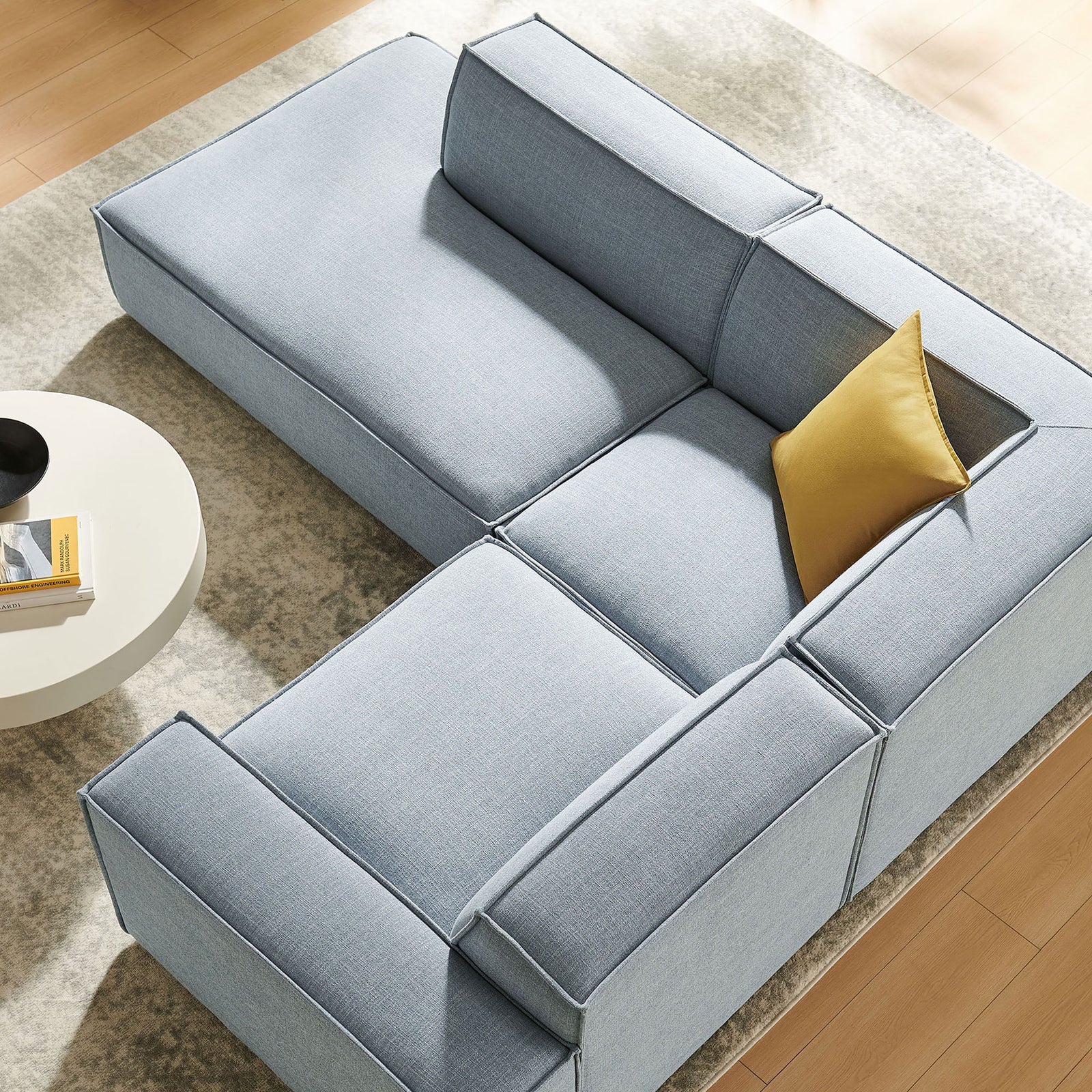 Sectional sofa in sky blue performance fabric arranged with a chaise and corner seat in a bright living room || EEI-7419-SKY || top_angle_room
