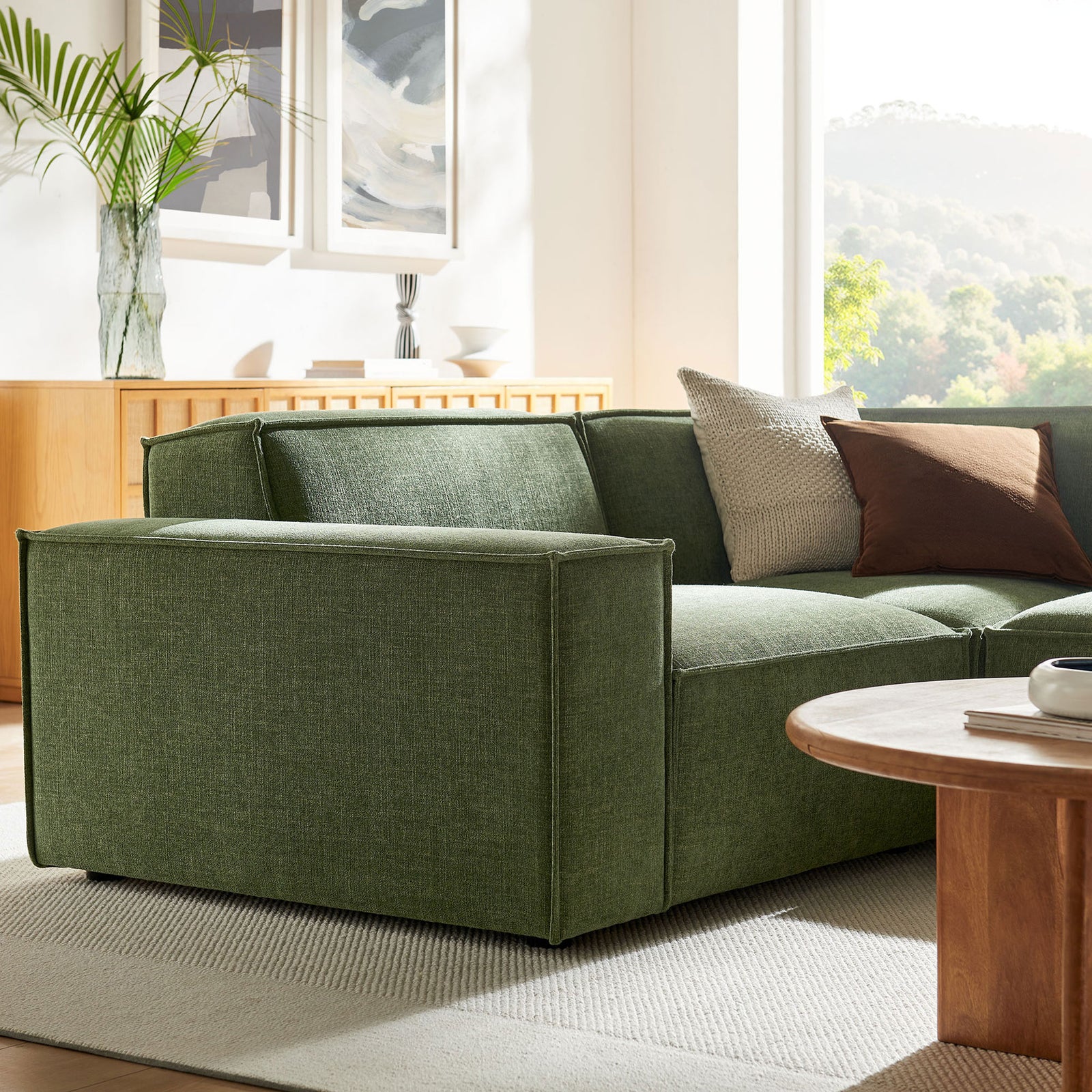 Textured green upholstery and broad track arm of the modular sectional with accent pillows in a living room || EEI-7421-FOL || detail_room