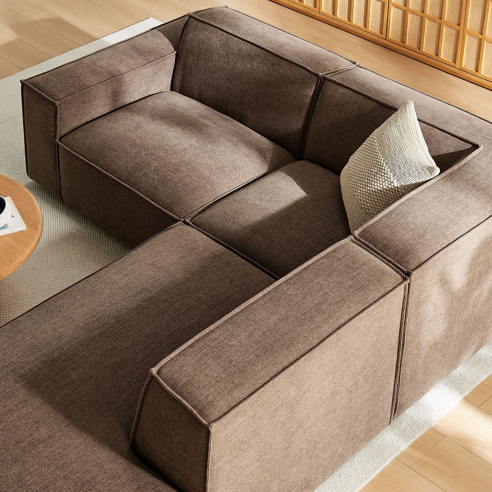 Sectional sofa and chaise form a cozy corner seating area beside a modern coffee table in a sunlit room || EEI-7421-MOC || top_angle_room