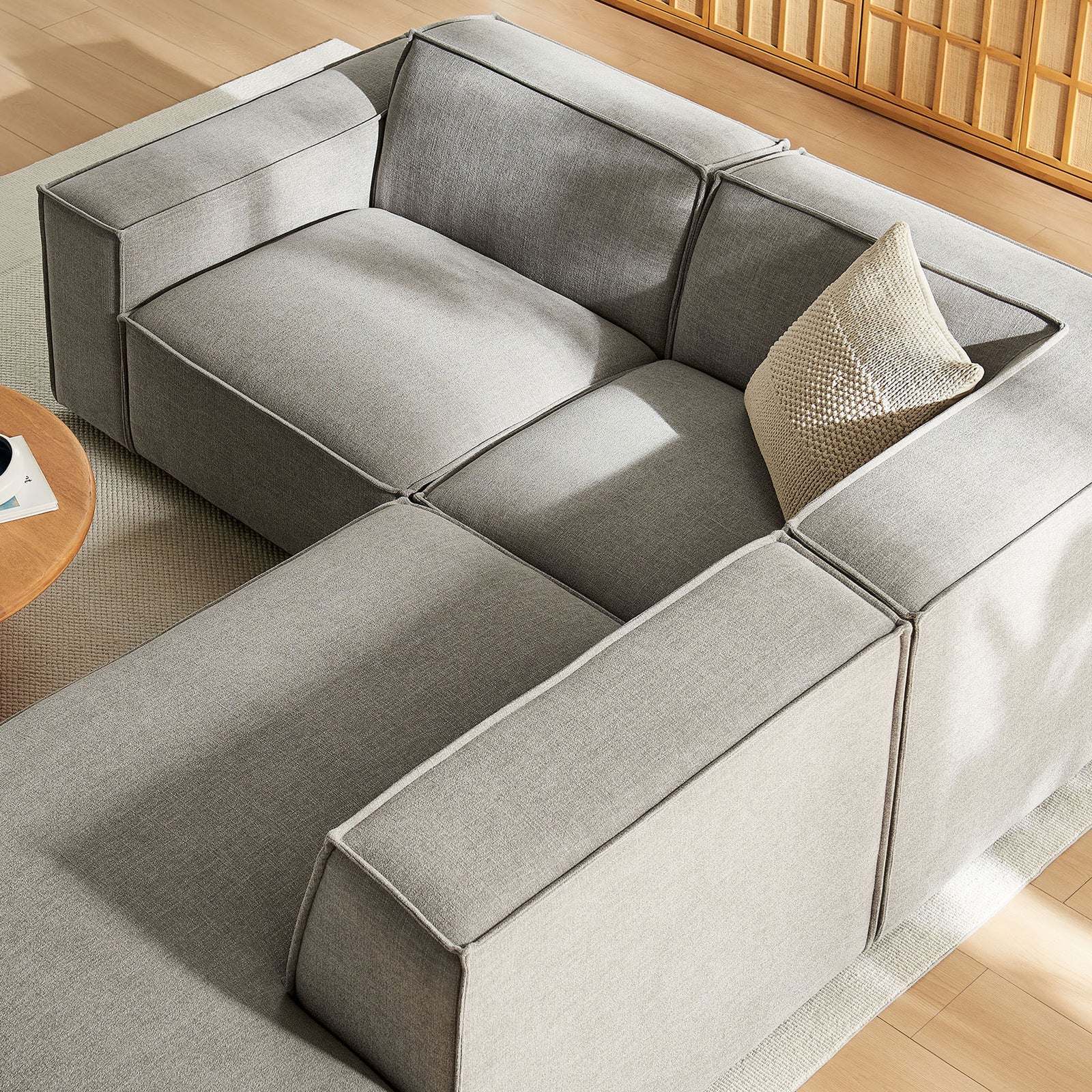 Detail of generously padded seat cushions and tailored French piping on the pewter sectional. || EEI-7421-PEW || detail_room