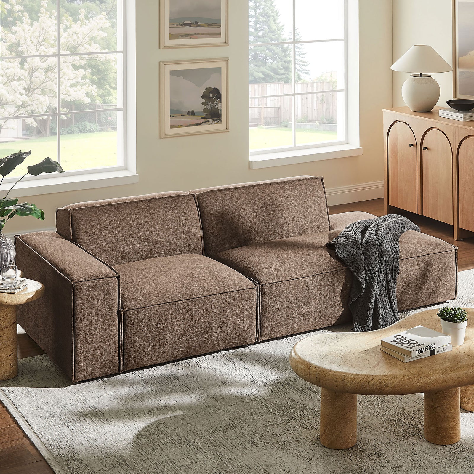 Mocha modular loveseat styled in a bright living room with rounded wood tables and soft rug || EEI-7425-MOC || front_angle_room