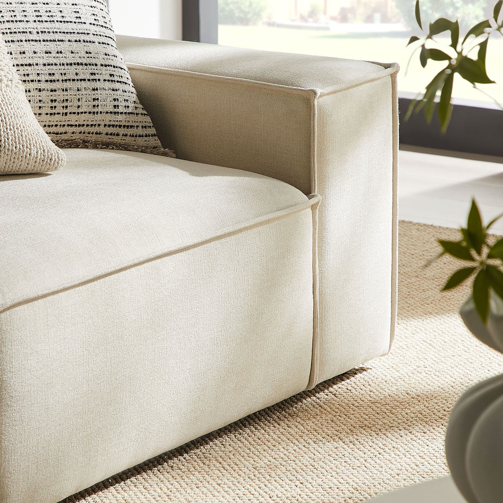 Right armrest and seat corner show the loveseat's crisp piping, plush cushion, and textured neutral pillows || EEI-7427-ECR || detail_room