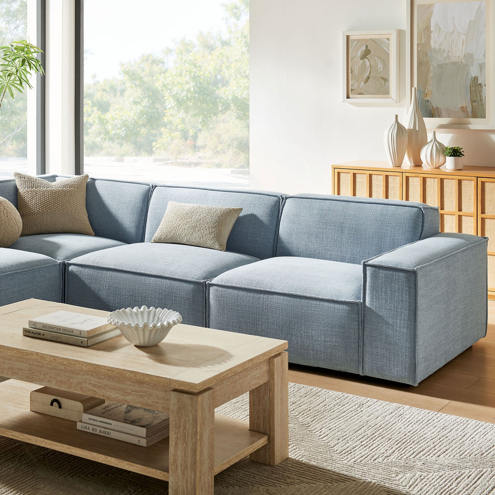 Sky blue modular sofa cushions with textured performance fabric and soft neutral accent pillows || EEI-7431-SKY || detail_room