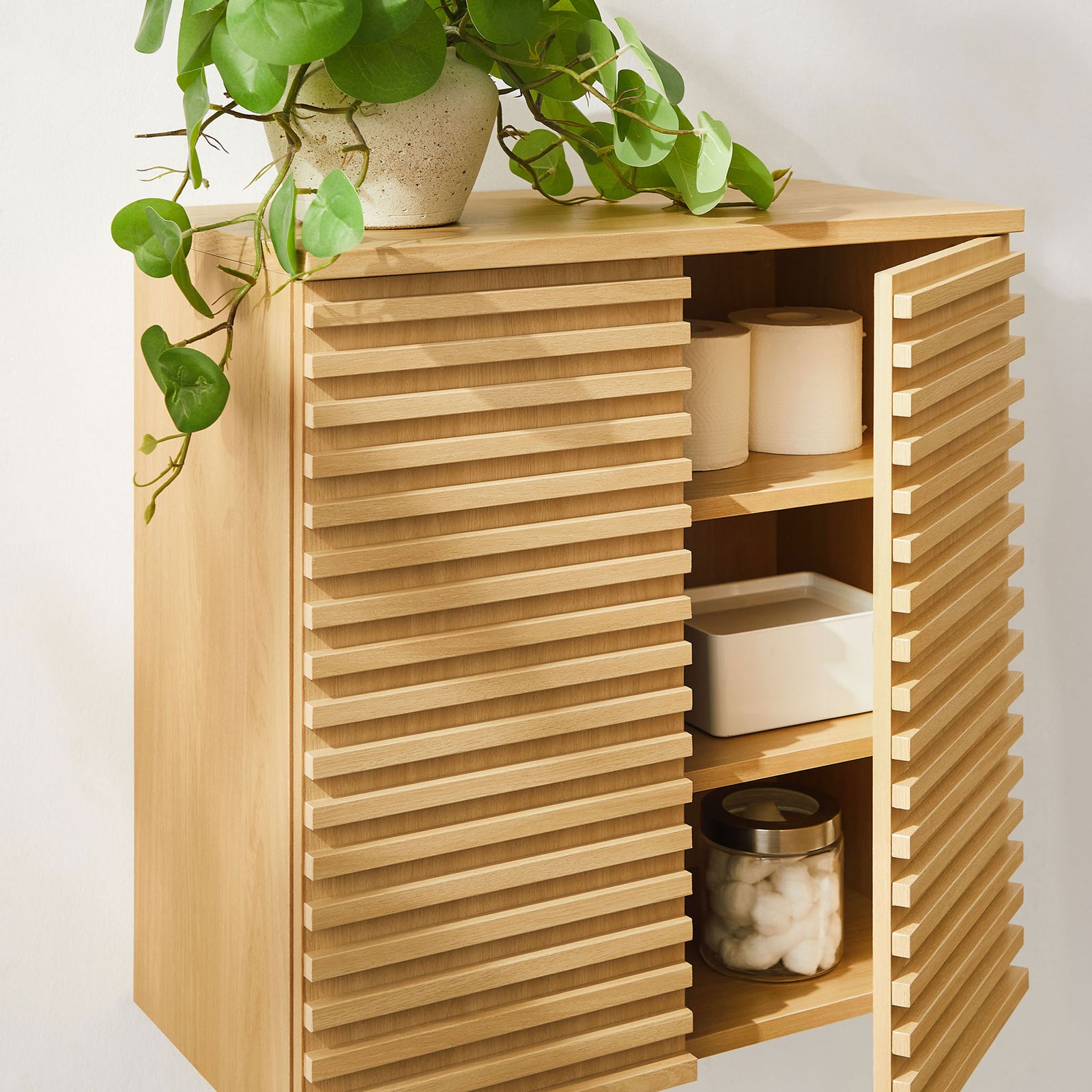 Wall-mounted oak cabinet shows convenient storage for everyday bathroom essentials || EEI-7438-OAK || front_angle_open_room