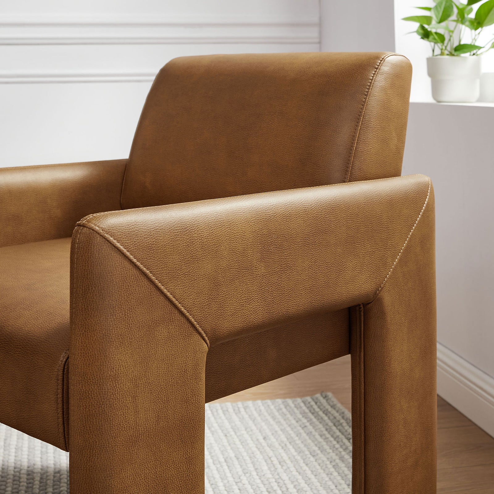 Canyon vegan leather armchair in a bright room, highlighting smooth curves and padded backrest || EEI-7443-CAN || detail_room