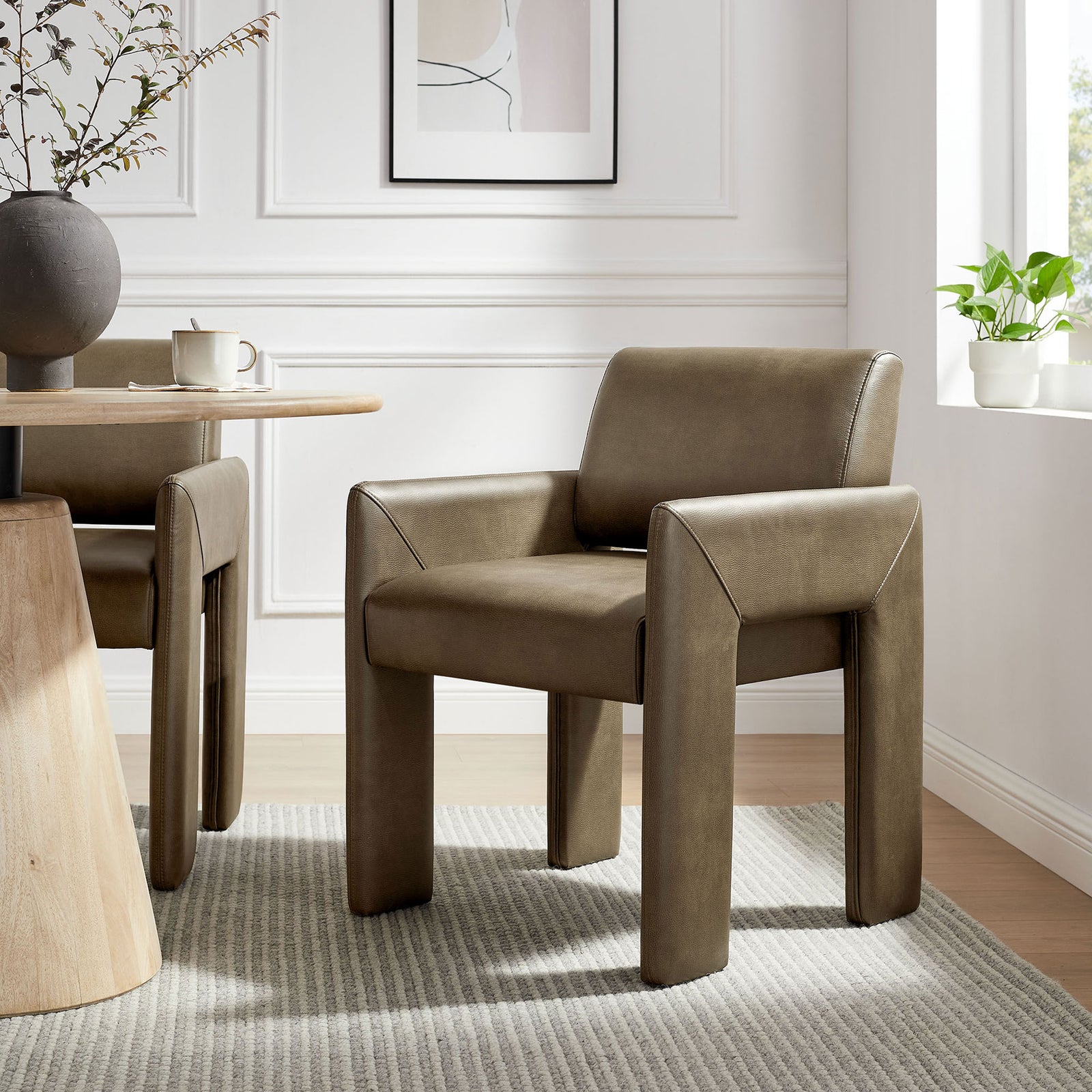 Modern mushroom vegan leather dining armchair styled in an airy dining room with wood table and neutral rug || EEI-7443-MUS || front_angle_room
