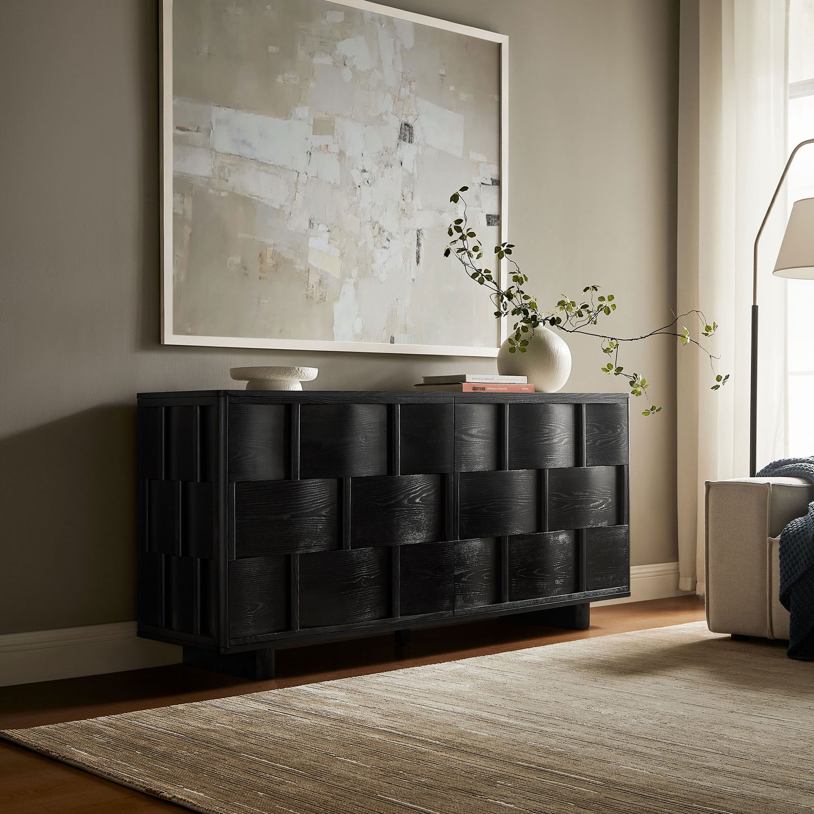 Black woven buffet cabinet styled in a modern living room beneath abstract wall art || EEI-7452-BLK || front_room