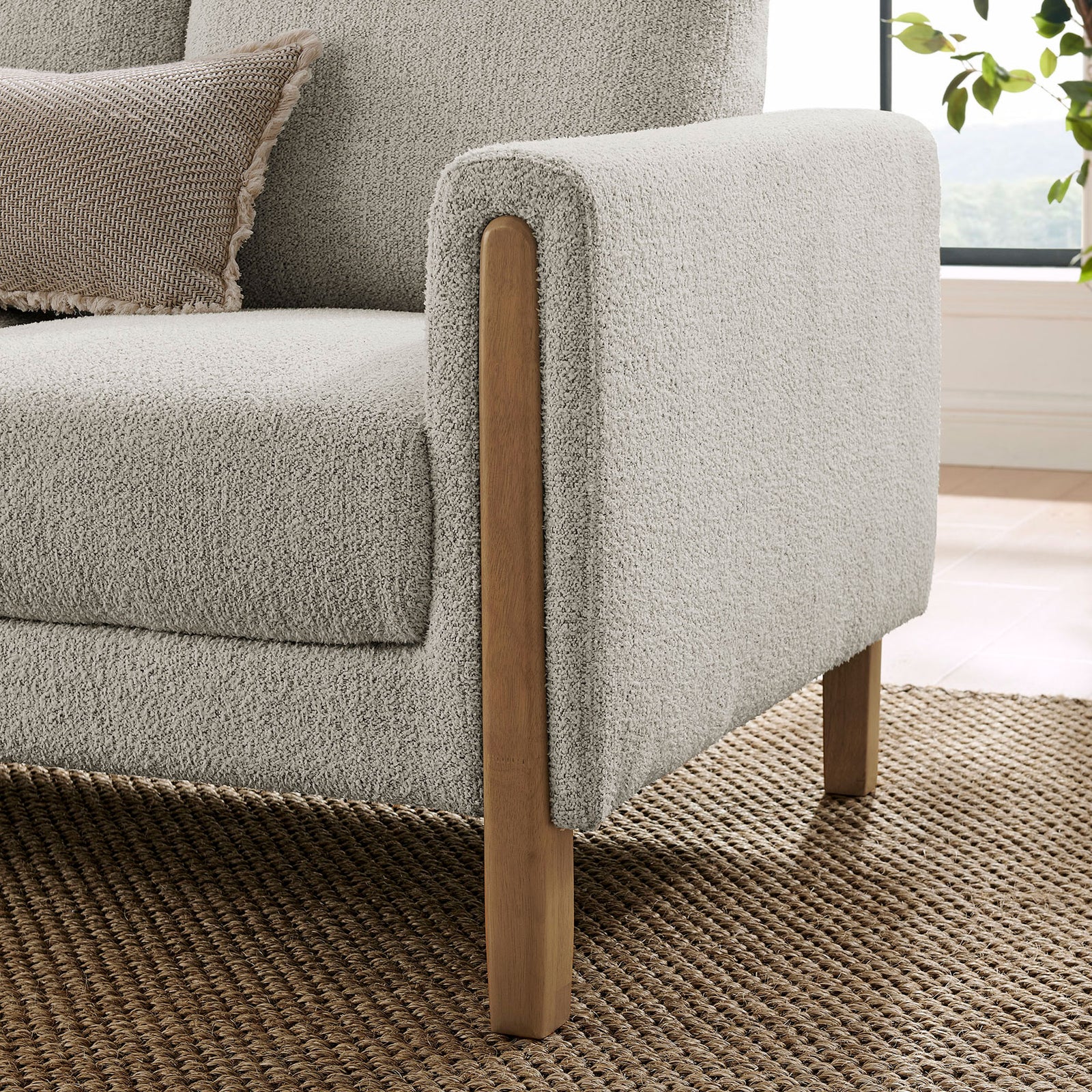 Wood-trimmed arm and round beech legs bring natural warmth to the textured boucle sofa || EEI-7461-PCH-BEE || leg_room