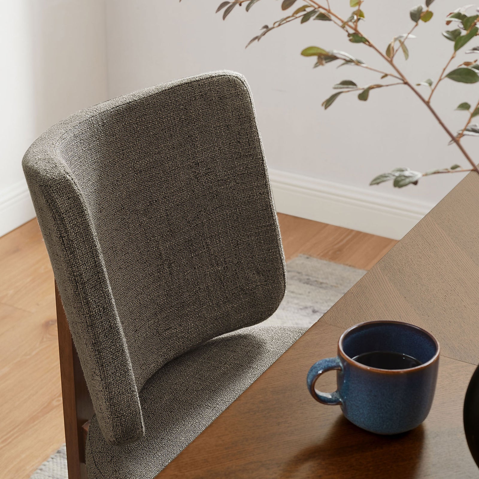 Cozy taupe dining chair tucked at a wooden table styled with modern decor for an inviting setting || EEI-7465-TAU || detail_room