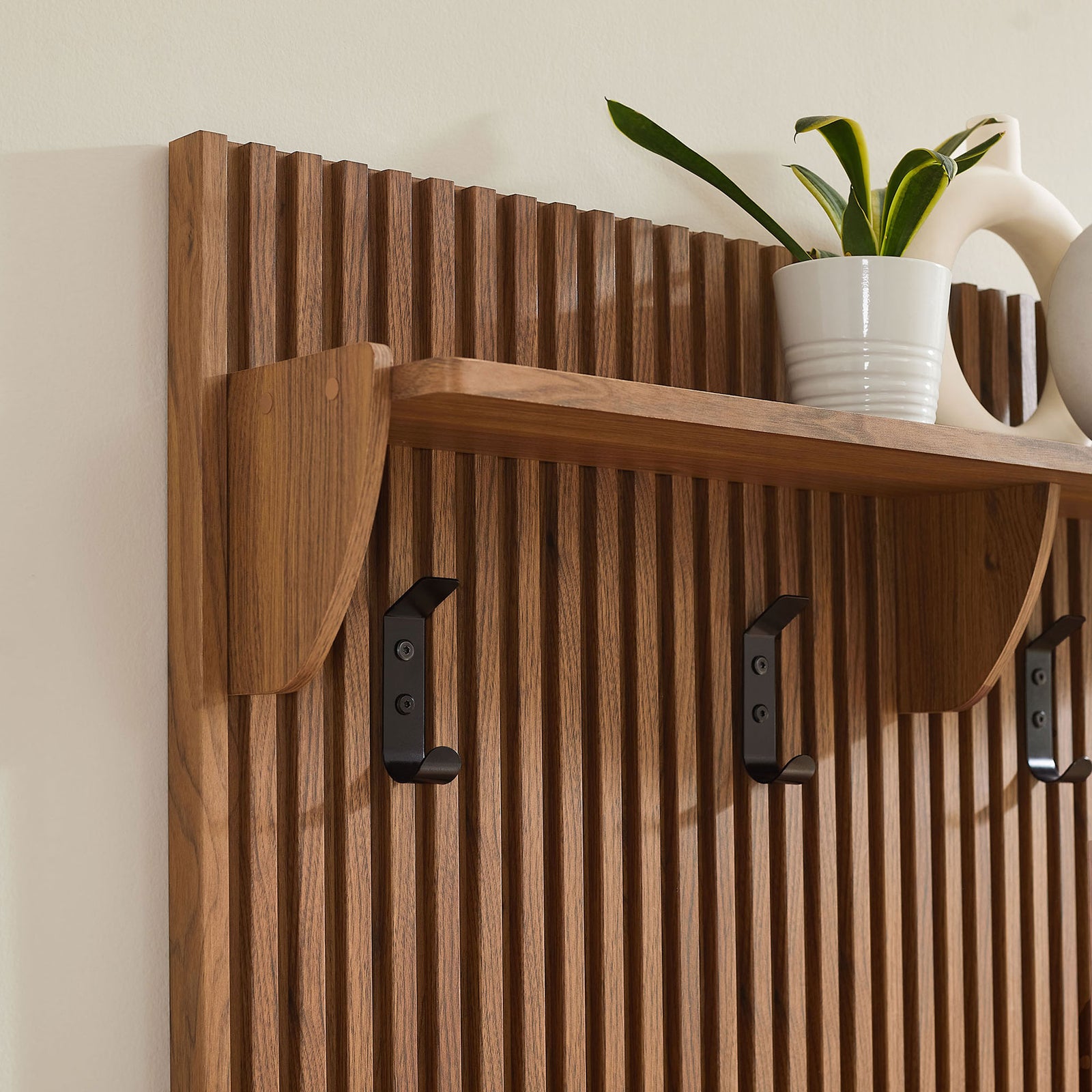 Walnut slatted panel with shelf and hooks adding warmth against a light wall || EEI-7472-WAL || storage_room