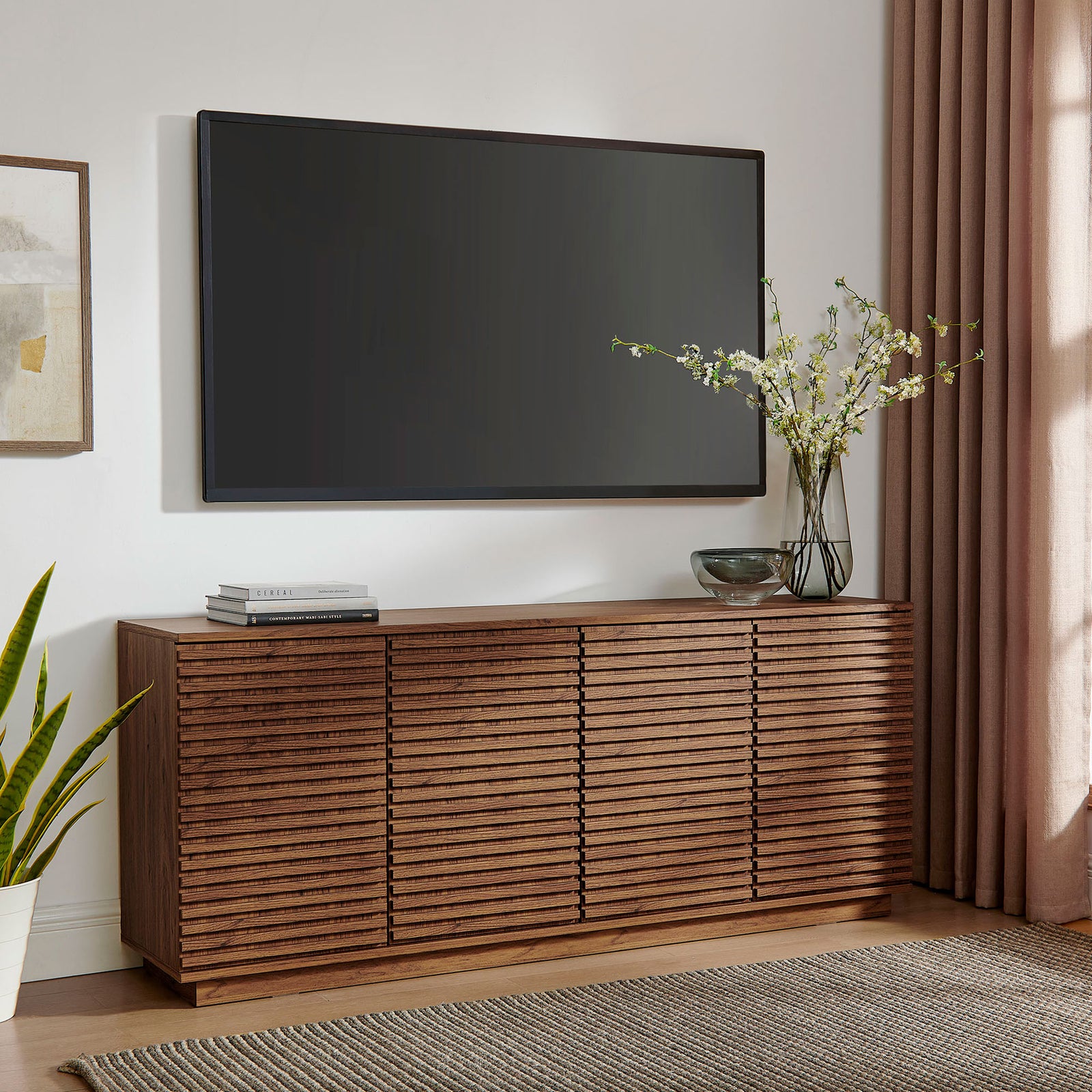 Walnut fluted sideboard used as a sleek media console beneath a wall-mounted TV in a contemporary living room || EEI-7477-WAL || front_angle_room