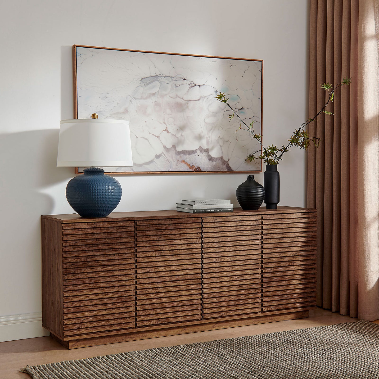 Walnut fluted sideboard styled with art, vases, and a table lamp for a warm, mid-century inspired living space || EEI-7477-WAL || front_angle_room