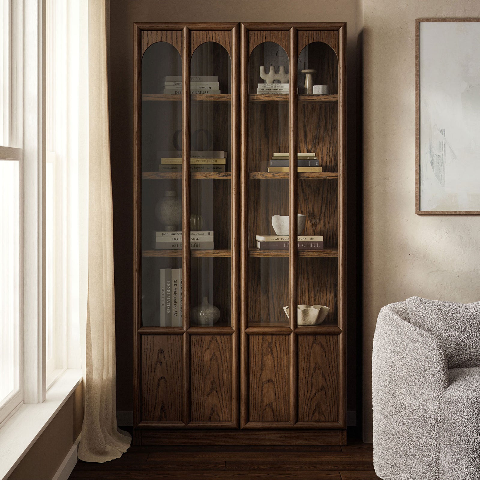 Walnut Anwen display cabinet arranged in a cozy room vignette with books and decor behind glass doors || EEI-7484-WAL || front_angle_room