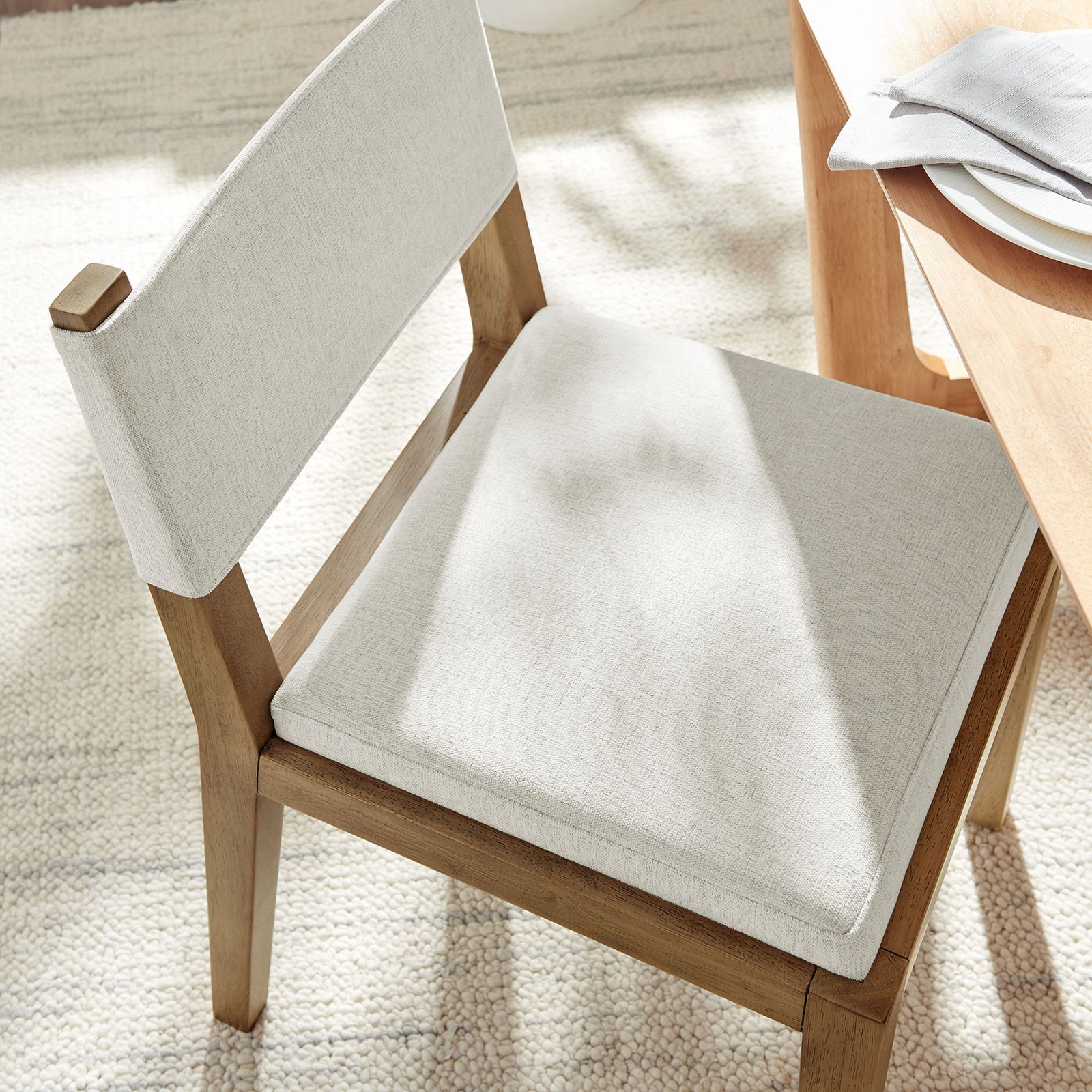 Ivory cushioned dining chair bringing soft texture and comfort to a bright dining space || EEI-7485-HEI || detail_room