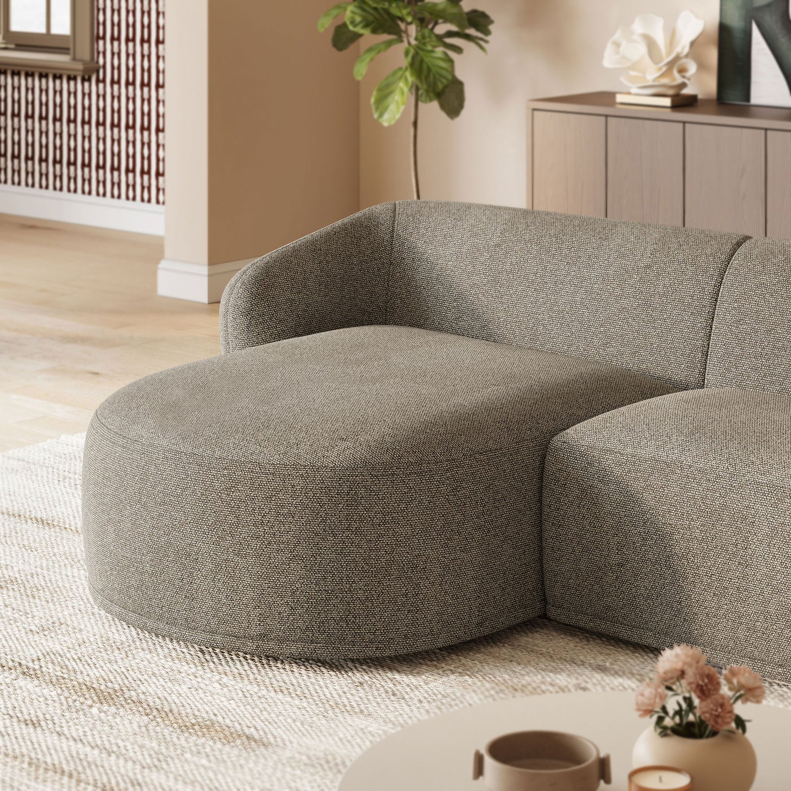 Rounded chaise in earth boucle styled with a neutral rug and soft decor for a cozy modern look || EEI-7502-ETH || detail_room