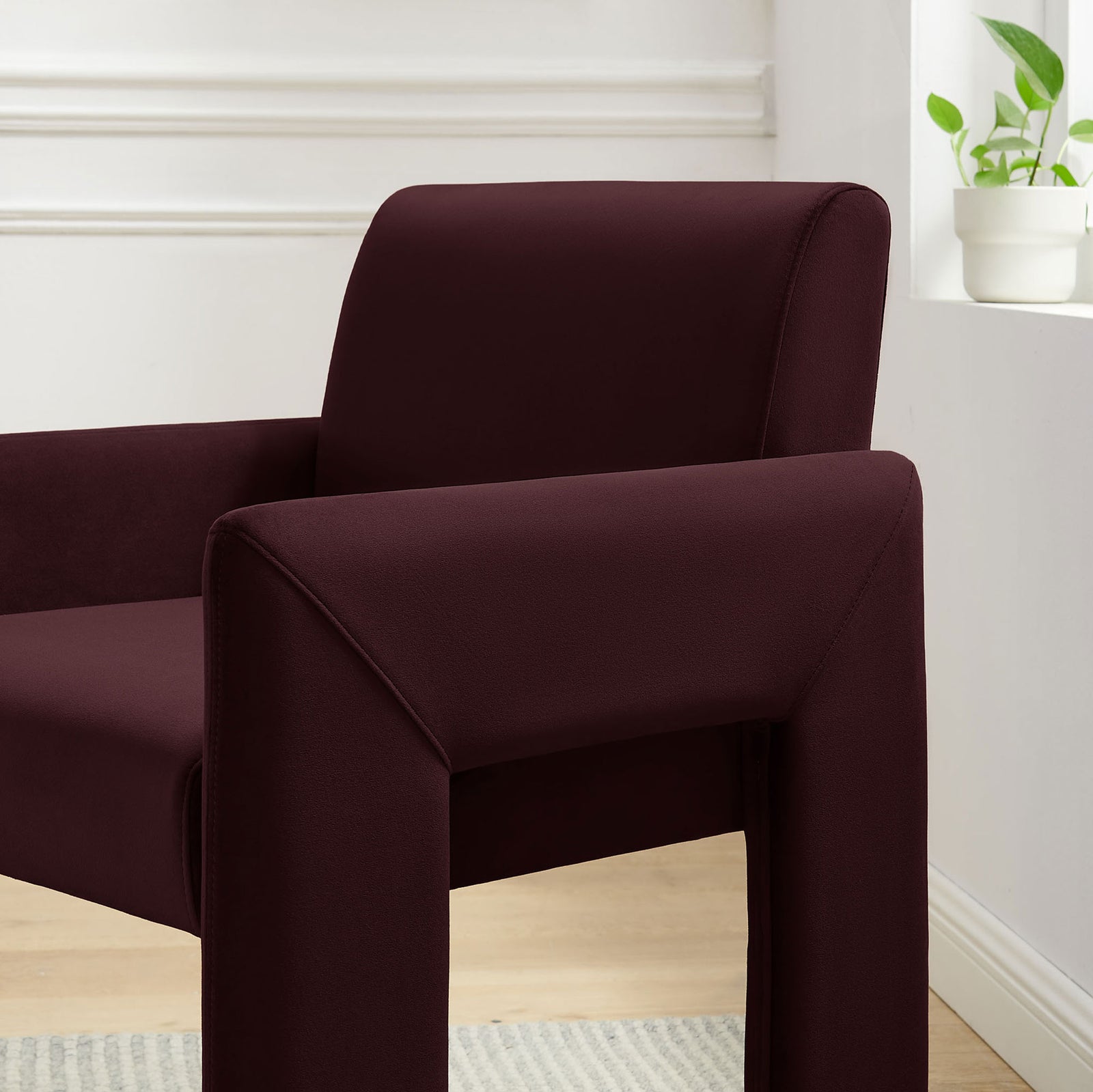 Mulberry velvet dining armchair styled in a bright dining nook beside a window plant || EEI-7525-MUL || detail_room