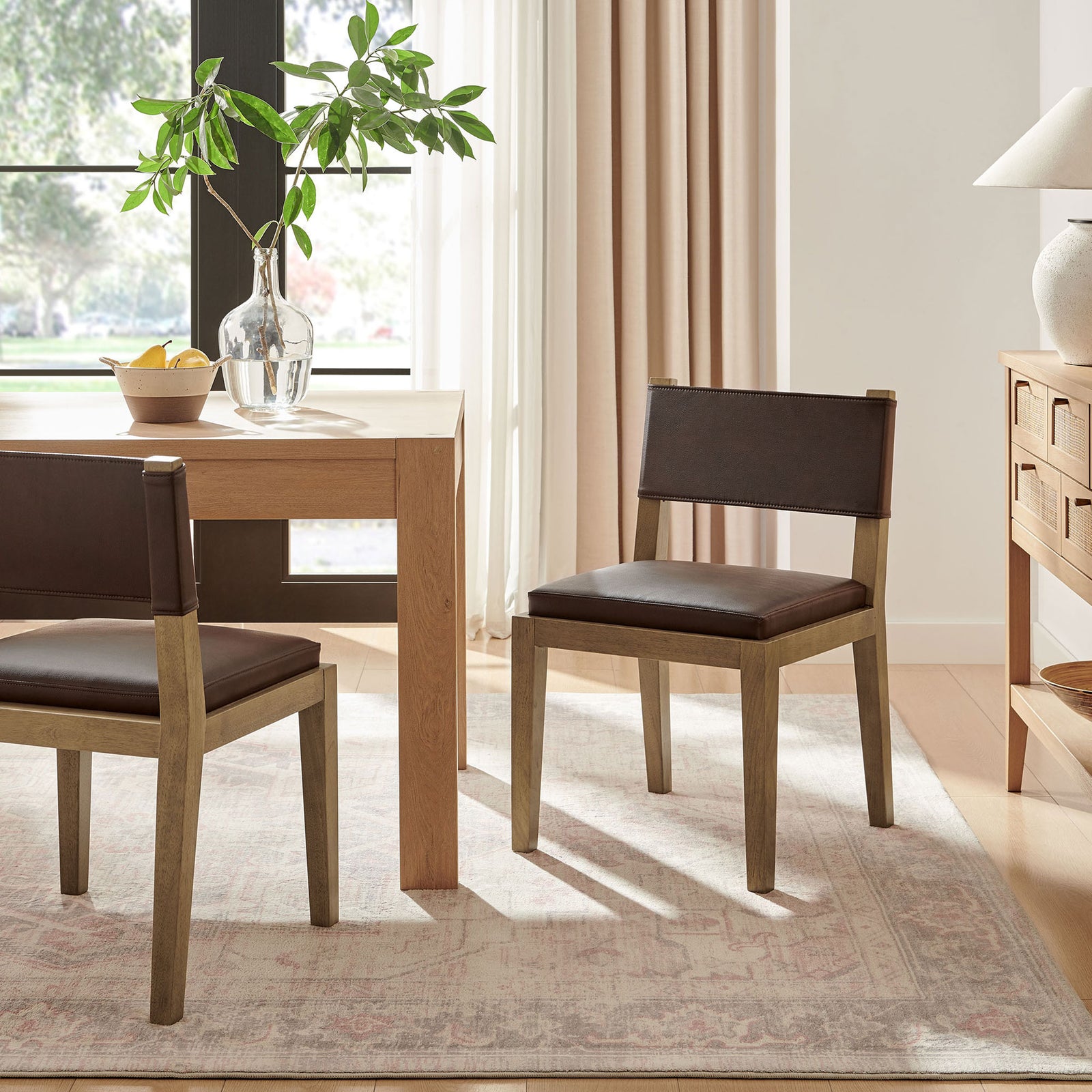 Pair of Calder dining chairs around a light wood table in a bright, airy dining room with soft neutrals || EEI-7527-ESP || front_angle_room