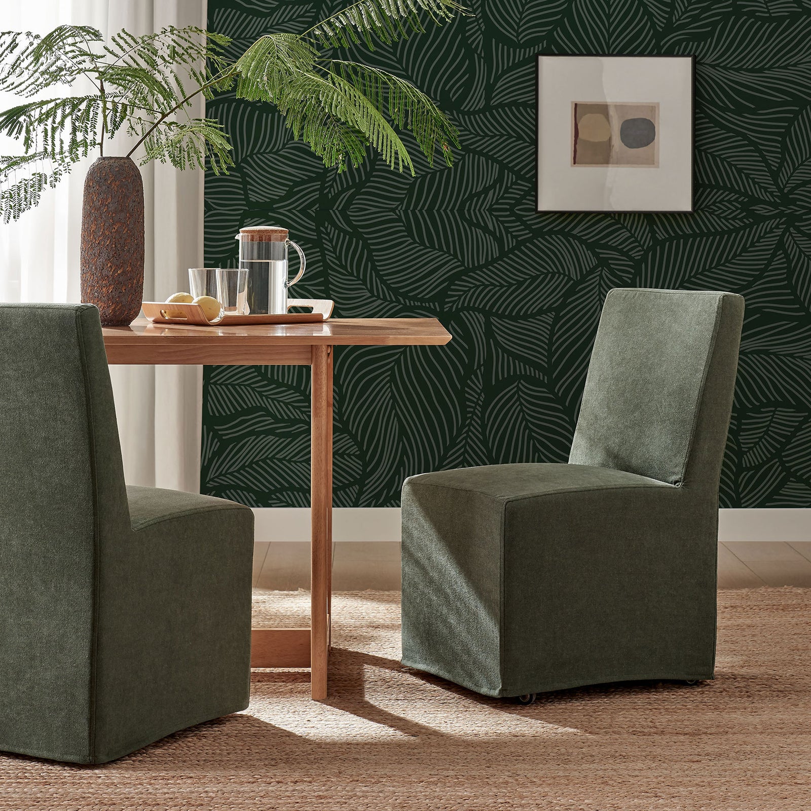 Pair of sage slipcovered dining chairs bringing soft color and clean lines to a modern nook || EEI-7528-SGE || front_angle_room