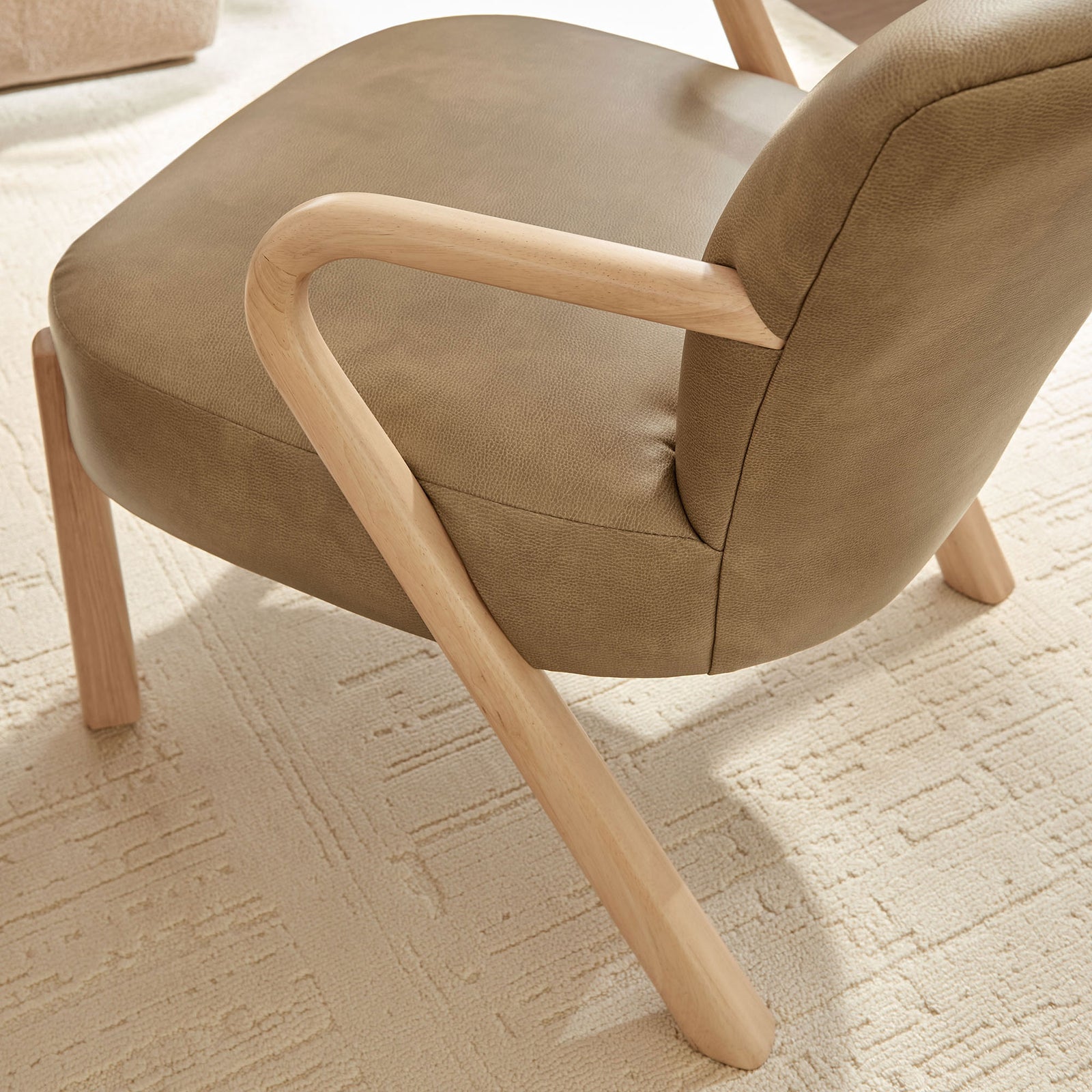 Light wood leg and arm detailing complement the textured vegan leather seat on a soft rug || EEI-7529-TST || leg_room