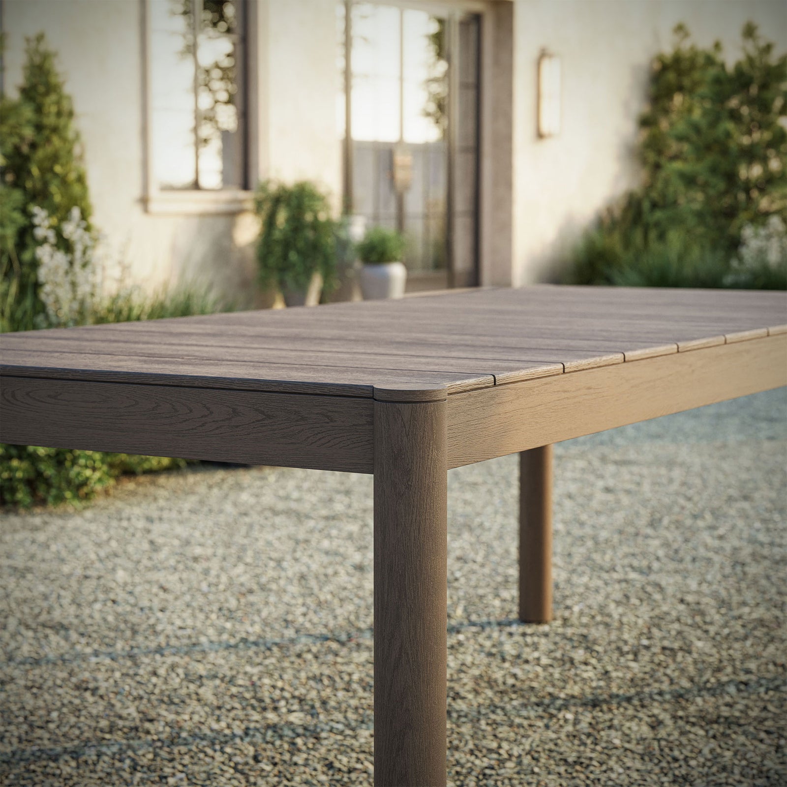 Weathered gray Eleni dining table adding rustic character to a relaxed open air gravel courtyard || EEI-7562-WGR || detail_room