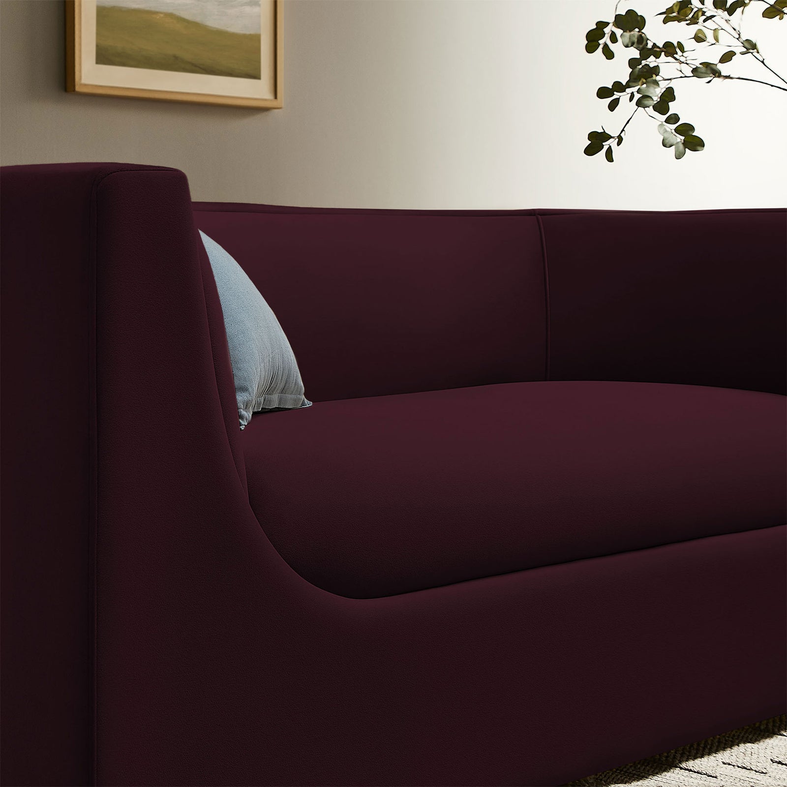 Mulberry velvet loveseat styled with an accent pillow, highlighting the curved back and smooth upholstery || EEI-7565-MUL || detail_room