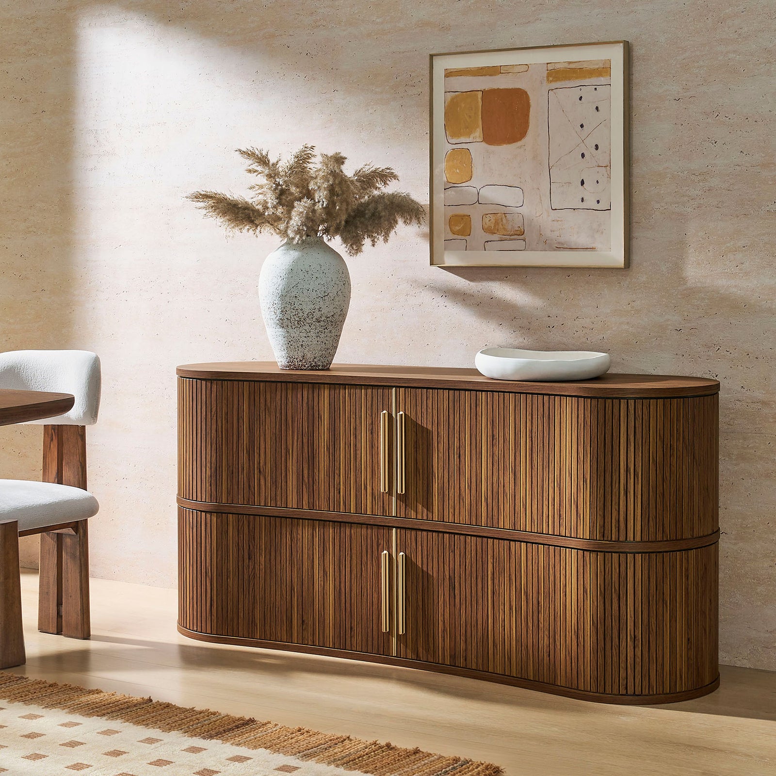 Curved walnut sideboard styled with decor, adding warm texture and modern elegance to the dining space || EEI-7583-WAL || front_angle_room