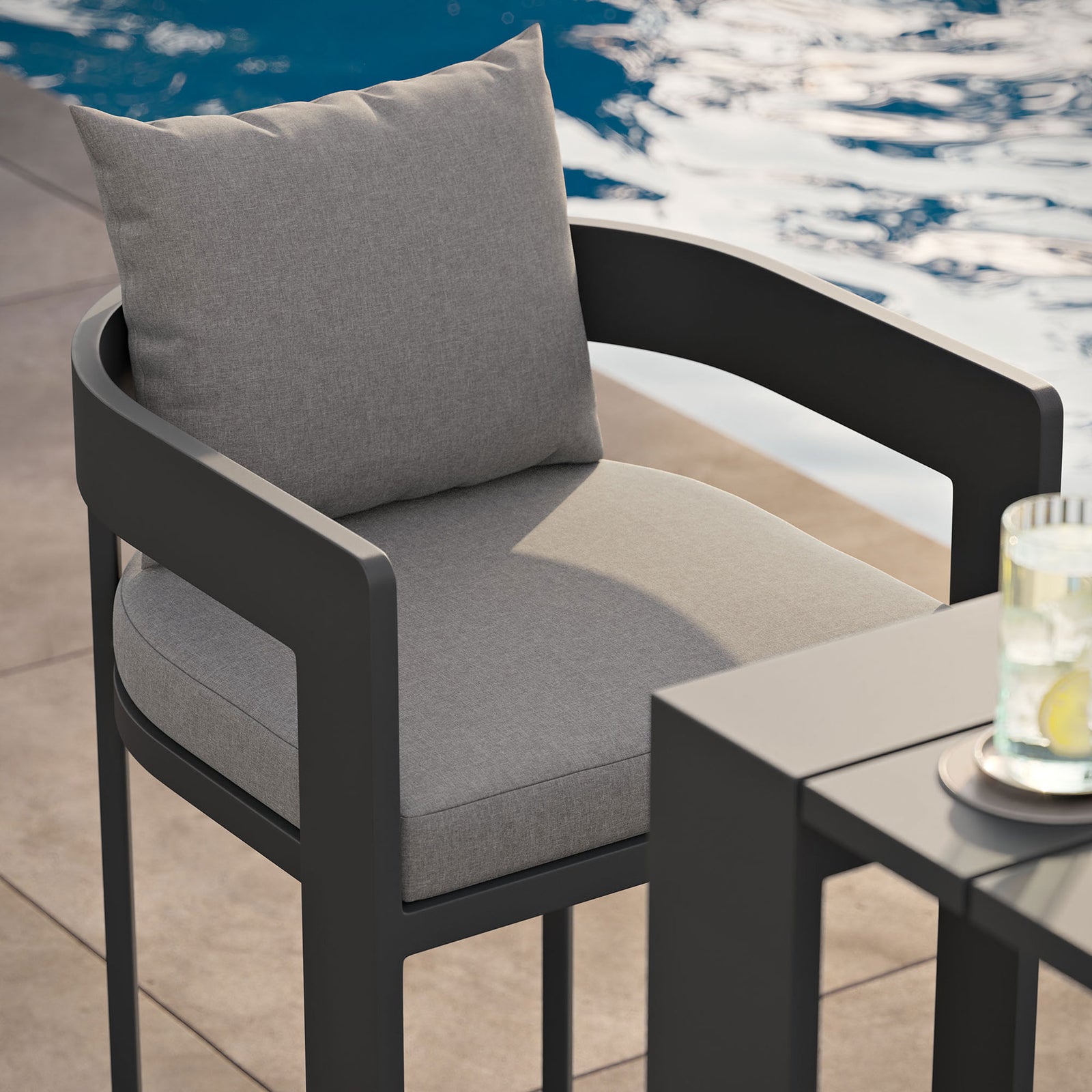 Tahoe bar chair beside the pool, highlighting gray cushions and dark aluminum frame at the bar. || EEI-7595-GRY || detail_room
