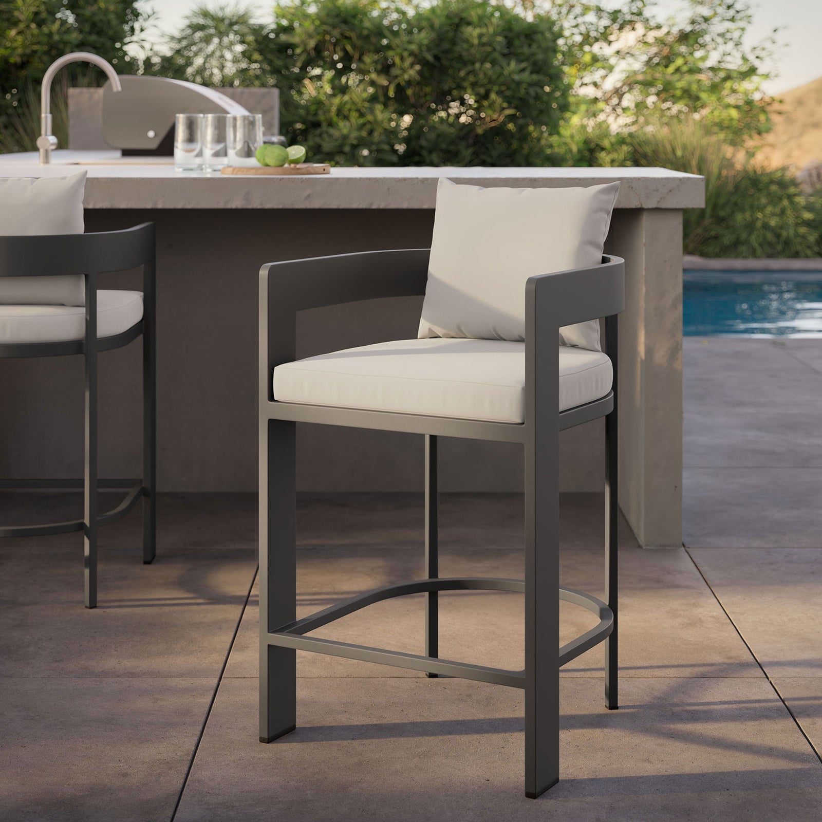 Tahoe counter stool by the pool, drawing attention to the white cushions and dark aluminum frame at the counter. || EEI-7596-WHI || detail_room