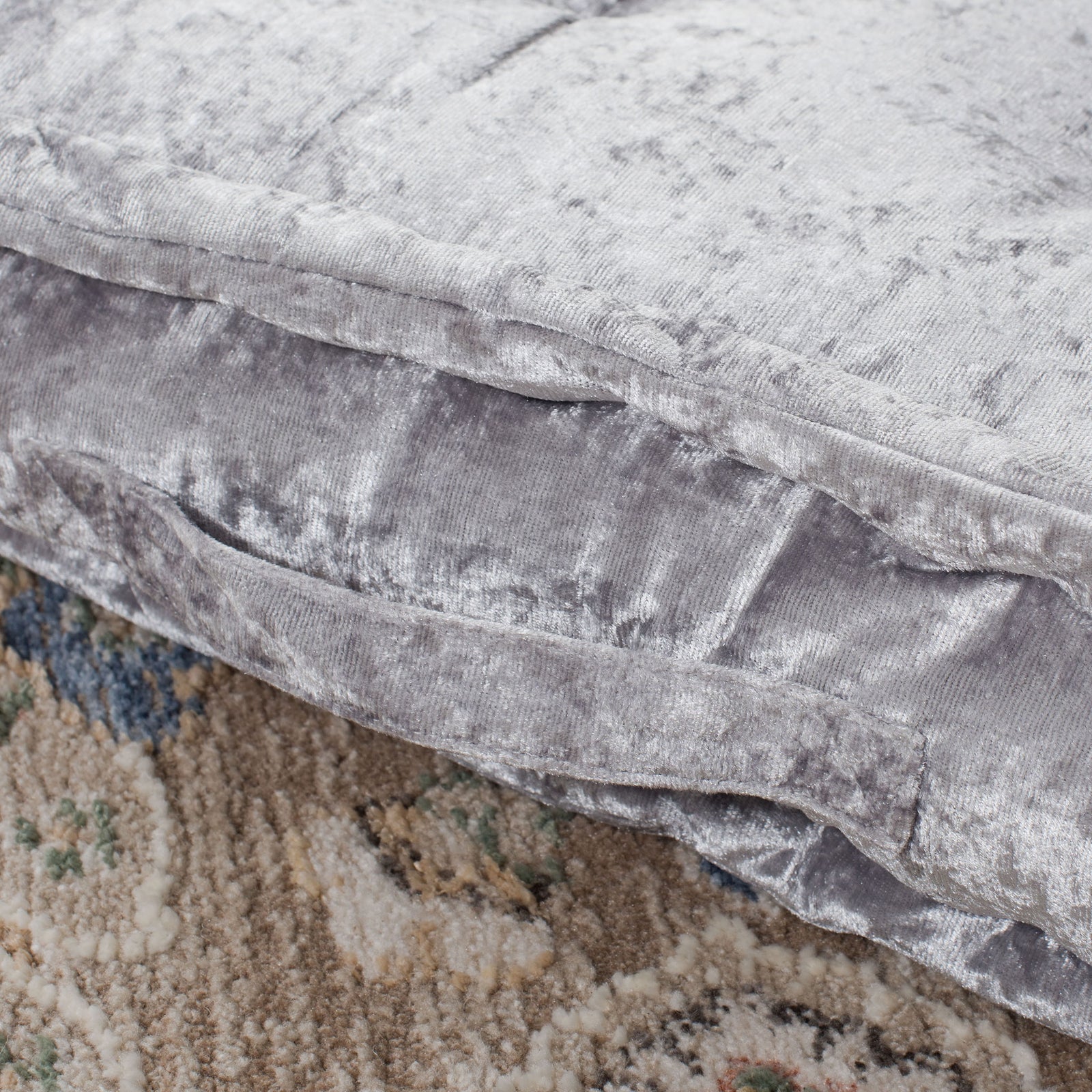 Shimmering silver fabric wraps a thick cushion with a neatly sewn, plush border. || FLP1001G-1818 || detail_room