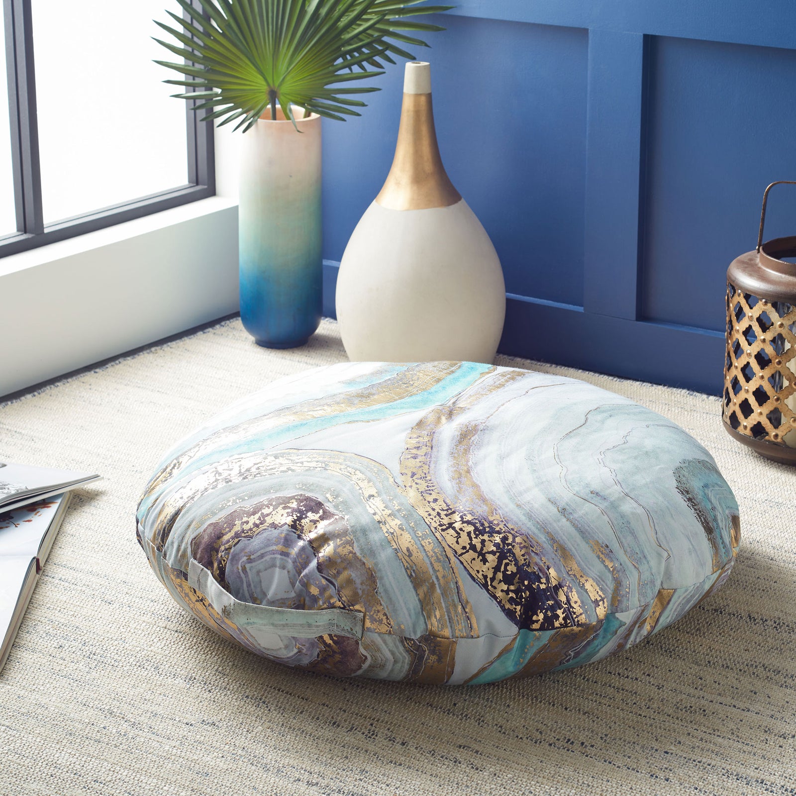 Thick round floor pillow with aqua, violet, and gold marbling and an easy-carry fabric loop || FLP1009A || front_angle_room
