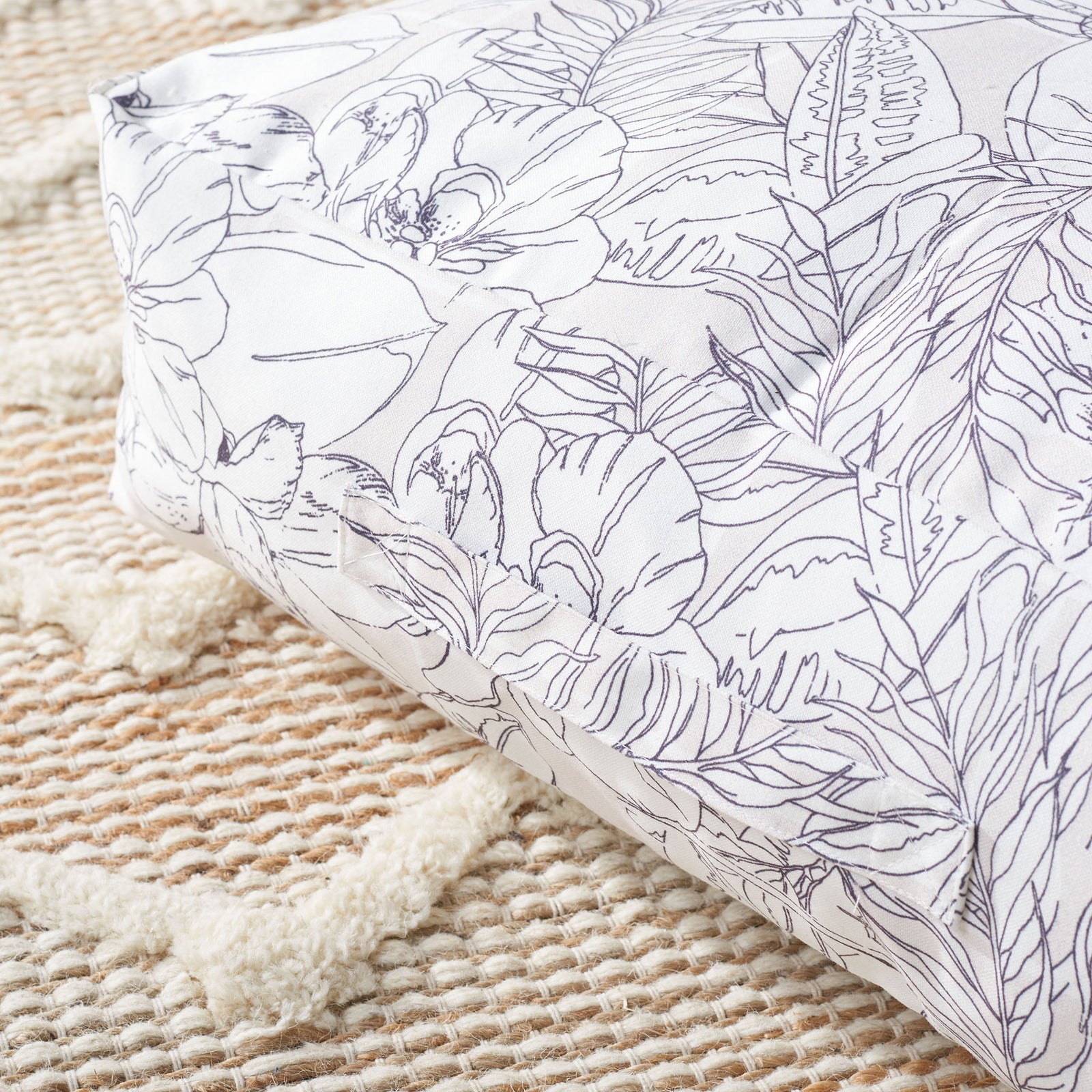 Soft beige fabric features intricate black floral outlines and neatly tailored corner seams. || FLP1012A || detail_room